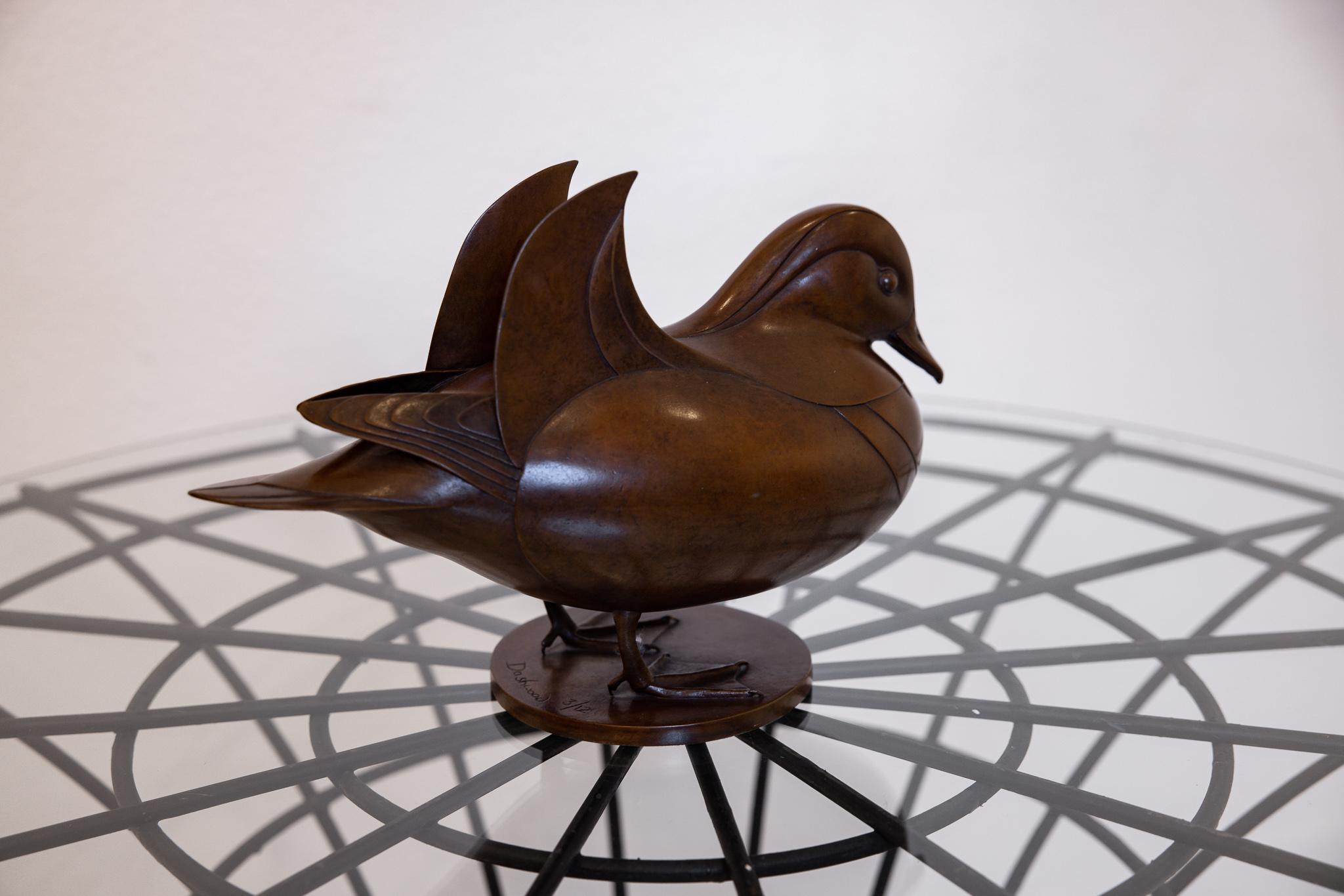 This is an excellent bronze stylized sculpture of a Mandarin Duck by Geoffrey Dashwood. Known for his use of simplicity, smooth surfaces, and continuous curved forms, this sculpture is an excellent representation of his work. Devoid of 