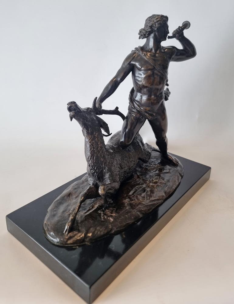 Modello in bronzo patinato di un cacciatore e un cervo, forse Ercole e il cervo di Ceryne di Holme Cardwell. Raffigurante una figura classica che indossa un mantello fluente e tiene un cervo per le corna con la mano destra mentre soffia una tromba