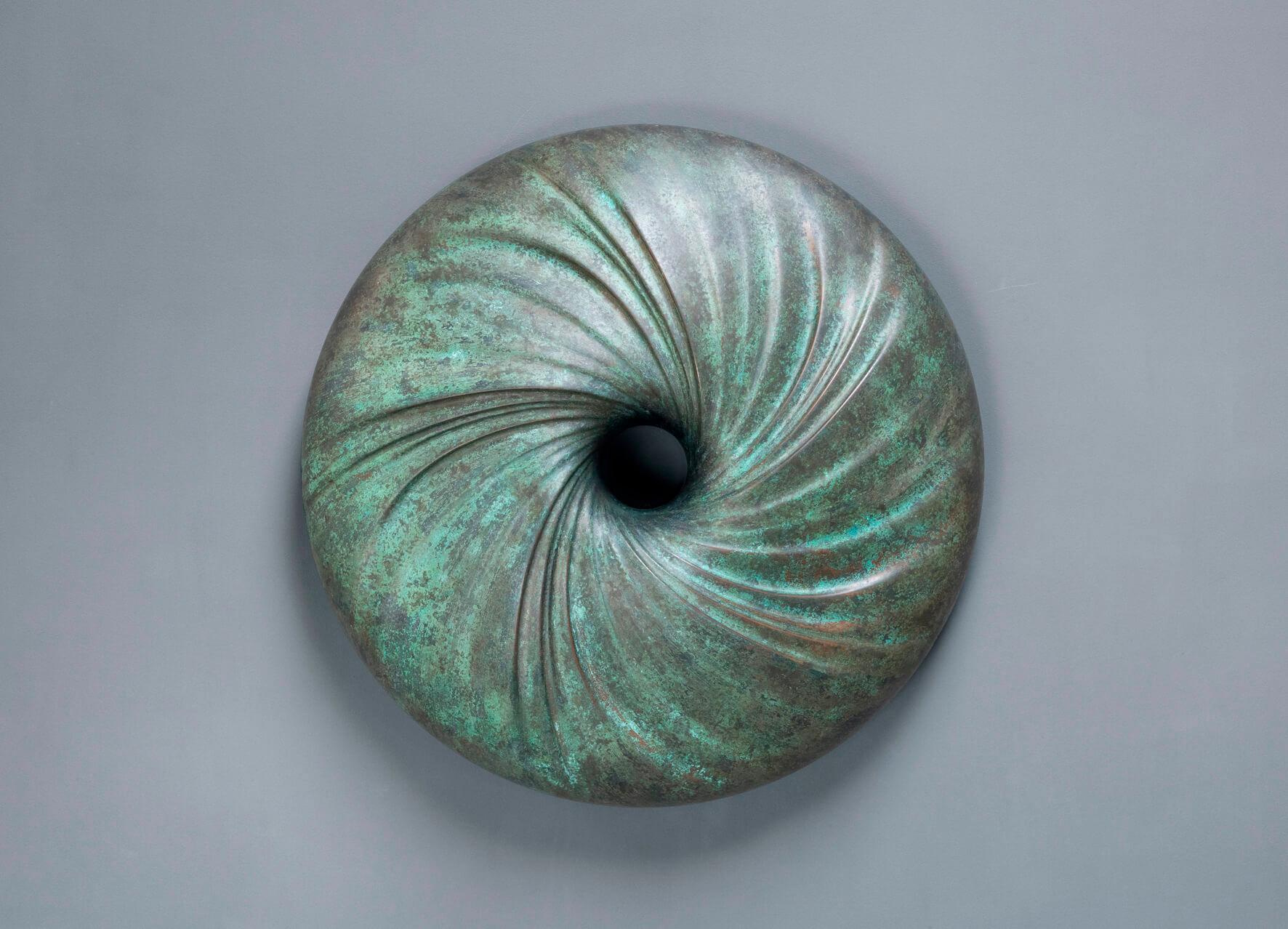 Bronze patiné Résine Maelstrom Sculpture murale par David Tragen
Dimensions :  L 49,5 x D 49,5 x H 9 cm
MATERIAL : Résine de bronze brossée.
Poids : 5 kg.

À propos de.. : Il a quitté l'université avec un diplôme en commerce international en 1994,