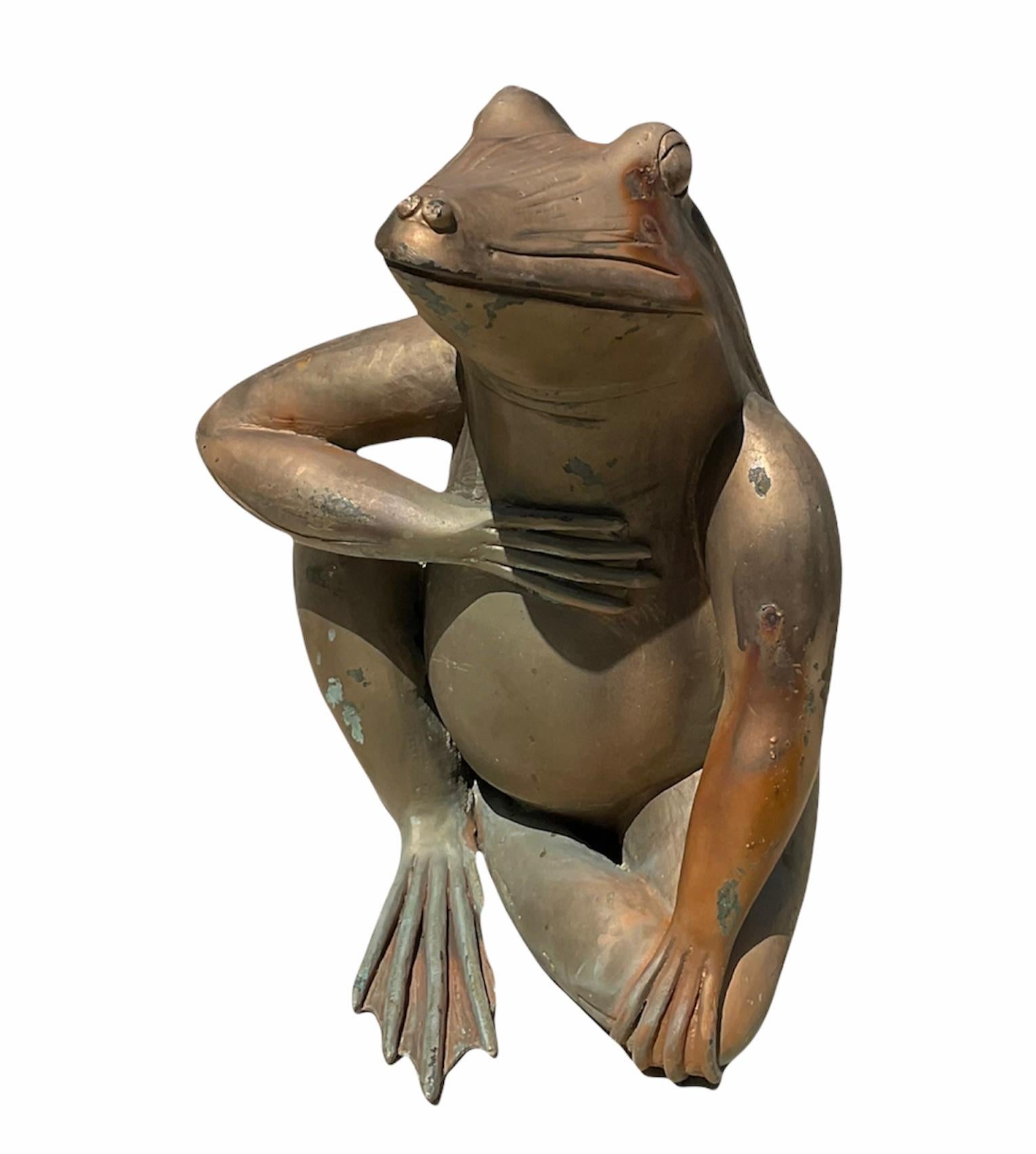 Il s'agit d'une sculpture en bronze patiné de taille moyenne représentant une grenouille assise avec la main droite dans la poitrine (son cœur). Ce geste symbolise la dignité et l'honneur. Cela signifie également qu'elle a une intention sincère ou