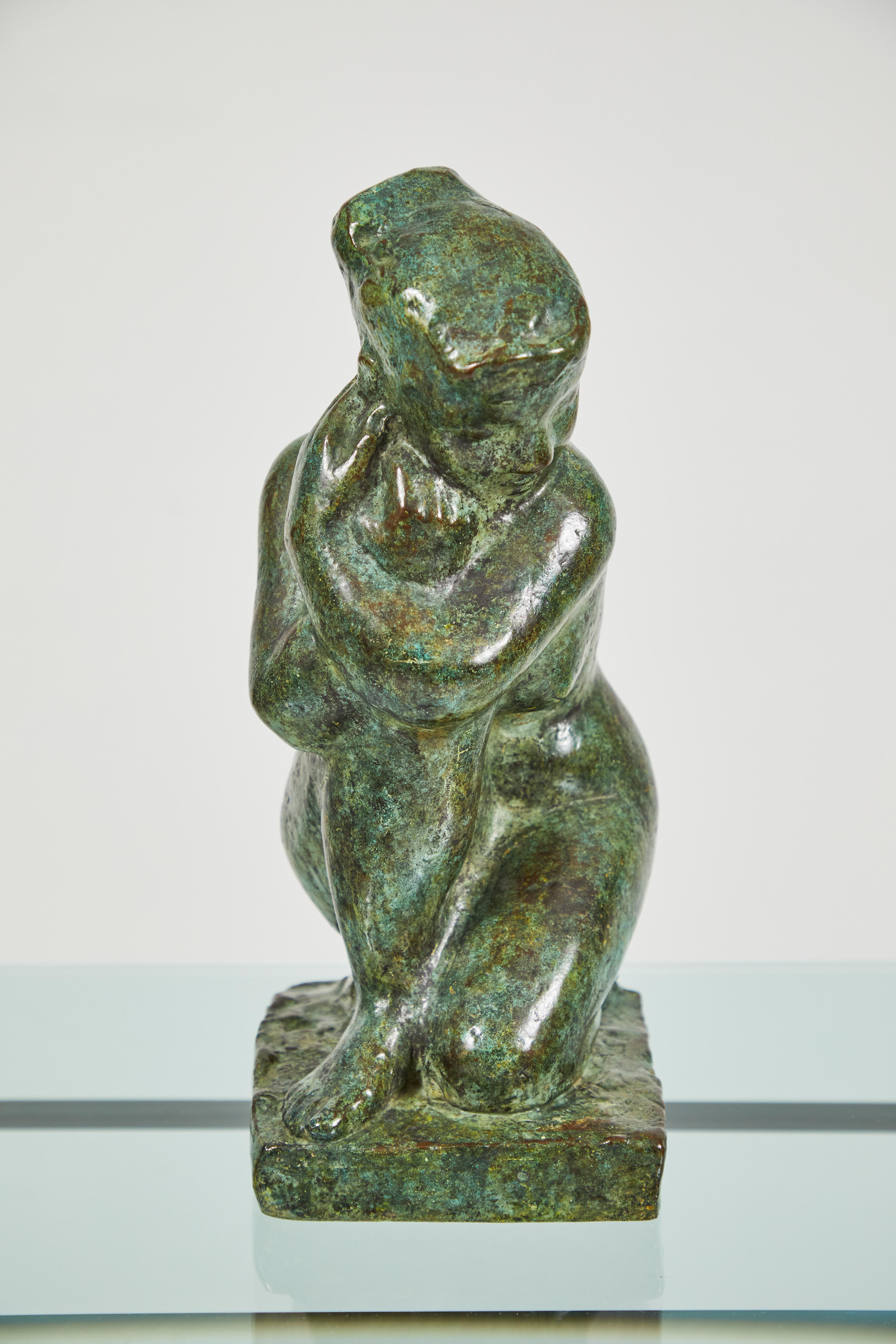 This is an exquisite bronze sculpture depicting a kneeling woman by Guy Charles Revol. Possibly another interpretation of Venus Kneeling, this young woman is kneeling on her left knee and resting her arms on her right knee, looking over her left