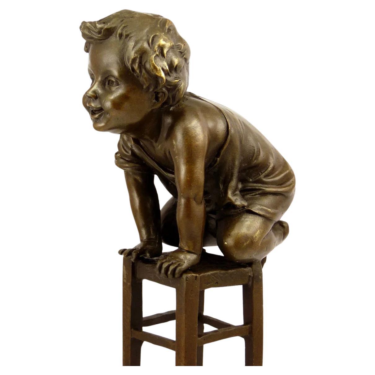 Escultura de bronce patinado de un niño sentado, estilo Art Nouveau, Siglo XX