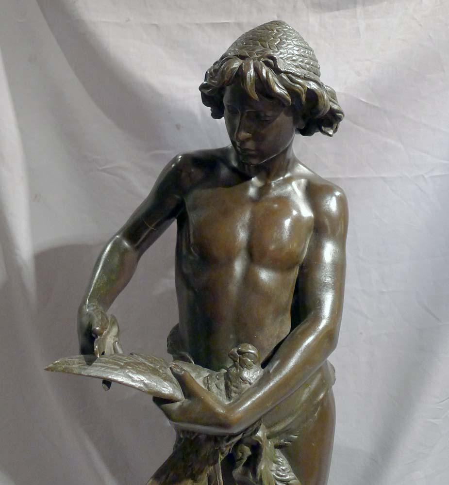 Patinated bronze sculpture of young boy trimming the wings of a dove by Gregoire. This bronze known as 