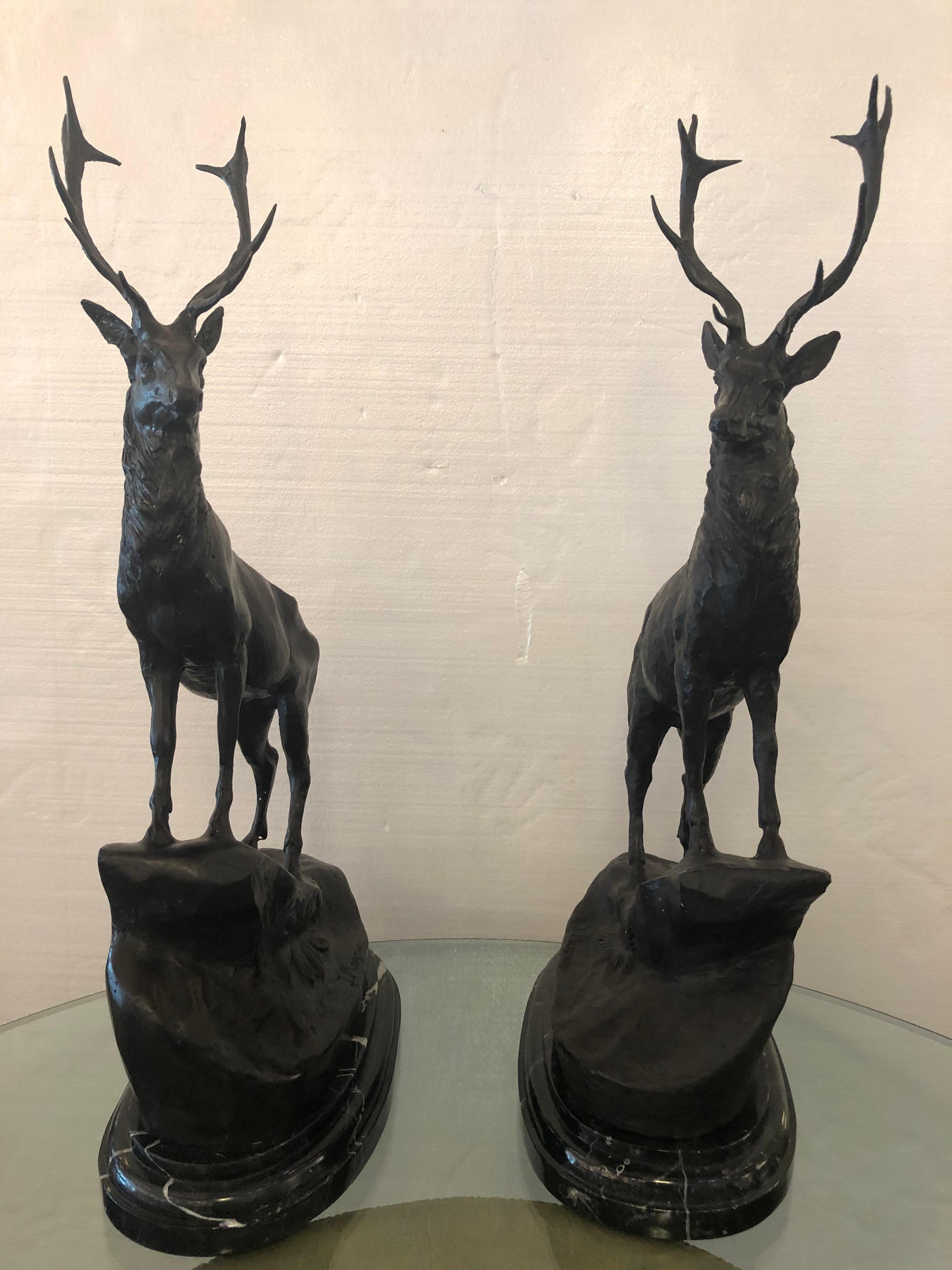 Patinated bronze stags standing over rocky outcrop, signed after Jules Moigniez with marble base.