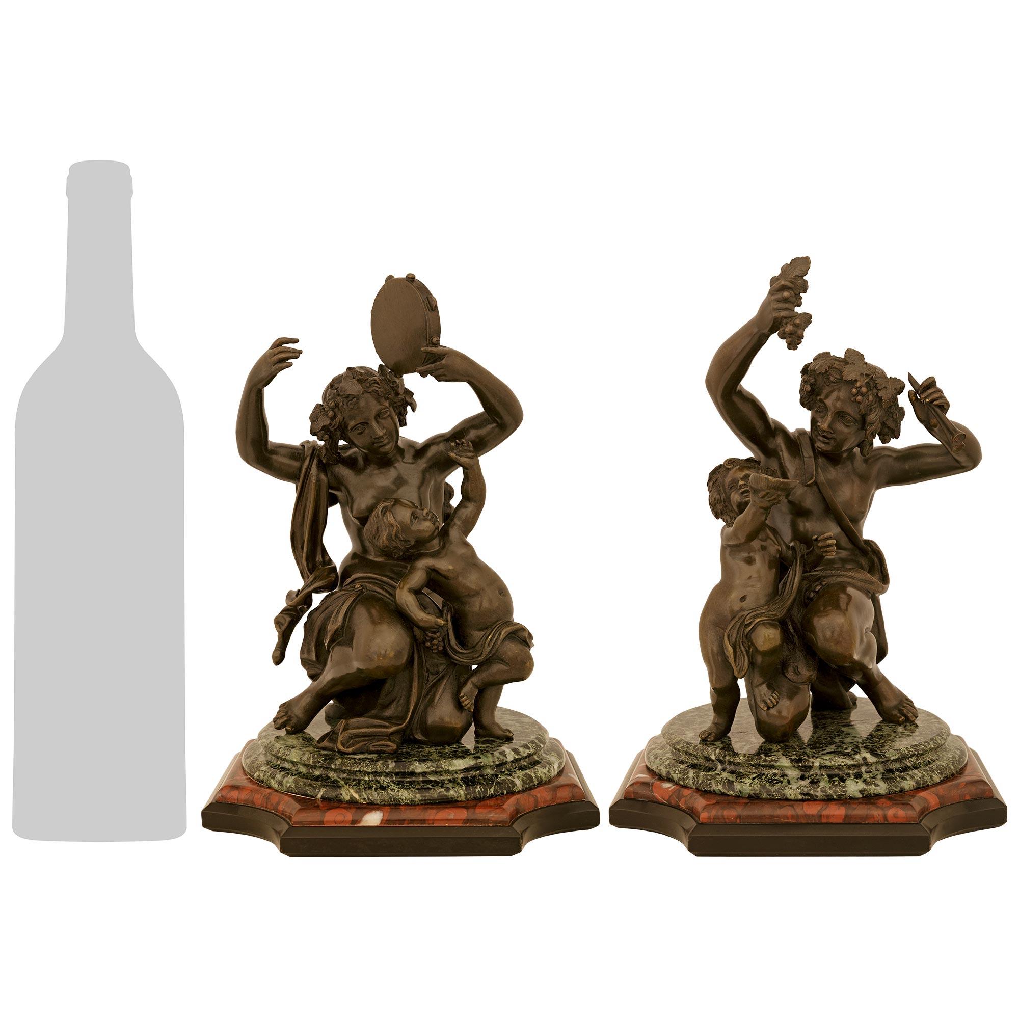 A wonderful and most decorative pair of French mid 19th century Louis XVI st. patinated Bronze, Verde Antico and Rouge Griotte marble statues. Each charming Bacchanalian statue is raised by a handsome square Black Belgian, Rouge Griotte and Verde
