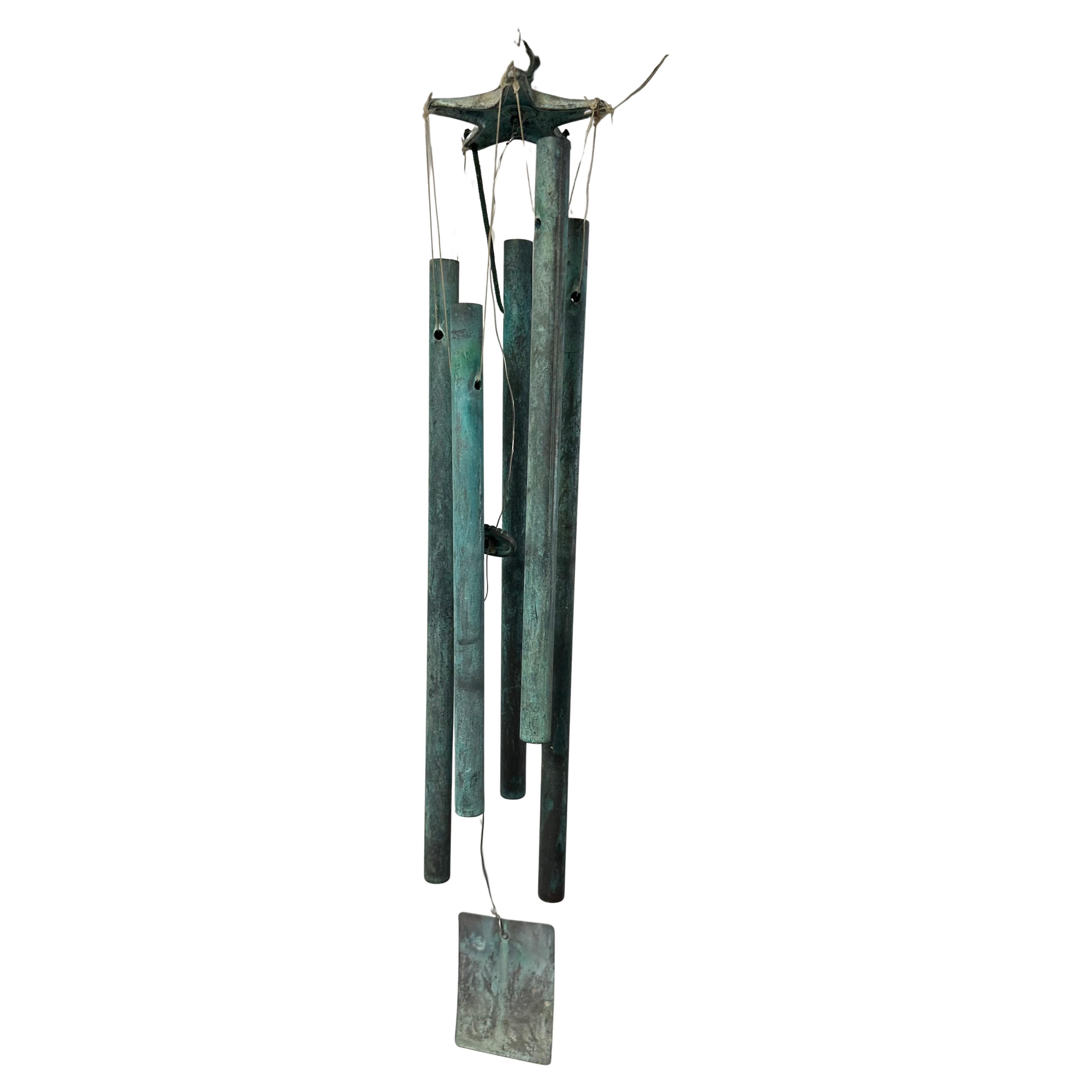 A wonderful set of patinated bronze wind chimes in the style of Walter Lamb, circa 1960s. This set features five patinated bronze tubes attached to a star shaped top with nylon rope. The chimes are in very good vintage condition with a gorgeous