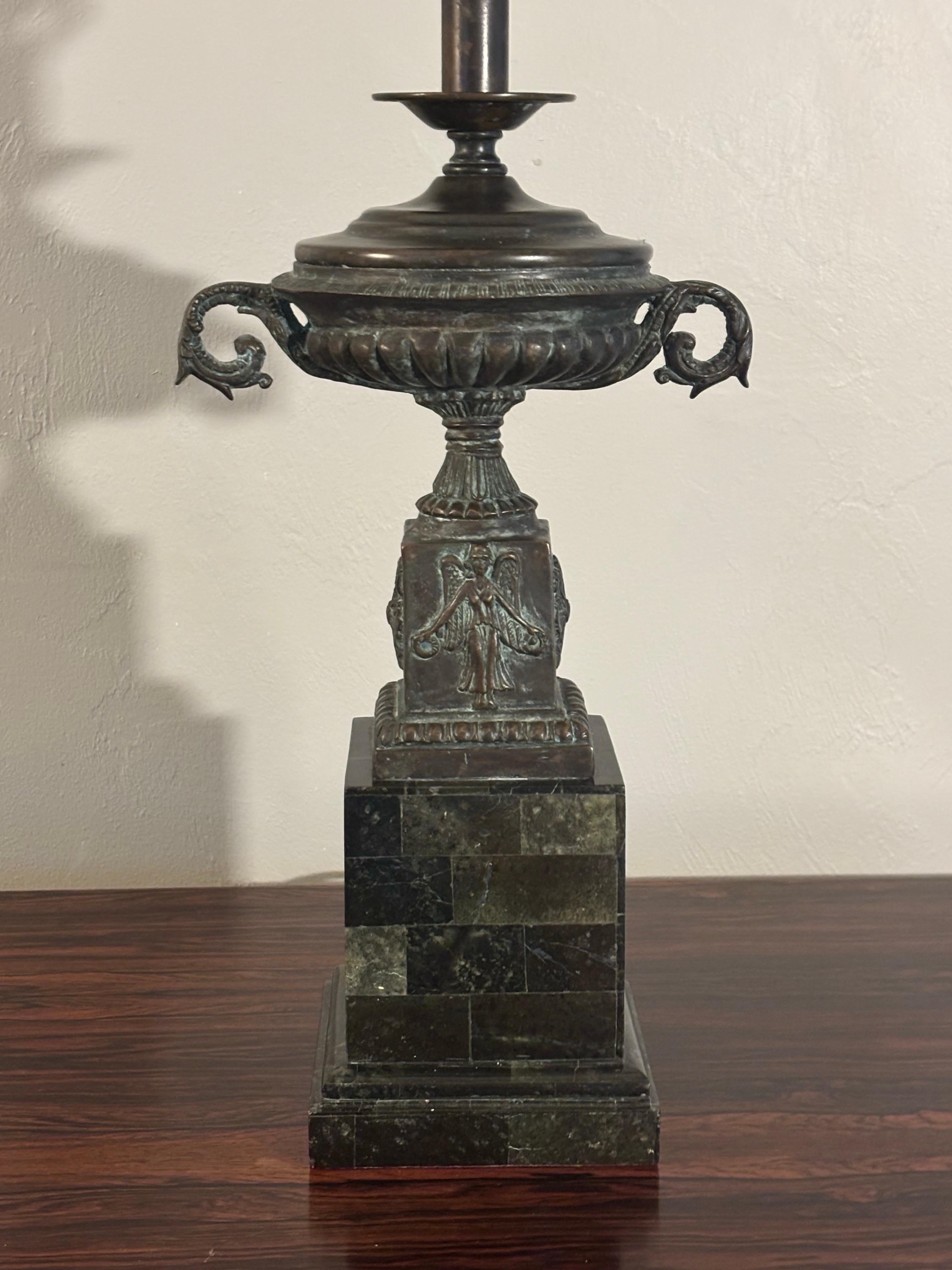 Striking and unique lamp by Maitland smith. Featuring a deep green tessellated stone base and a patinated bronze or copper urn with tons of accent decoration and beautiful coloring. Comes with a custom matching finial. 

Works with a 3 way bulb.