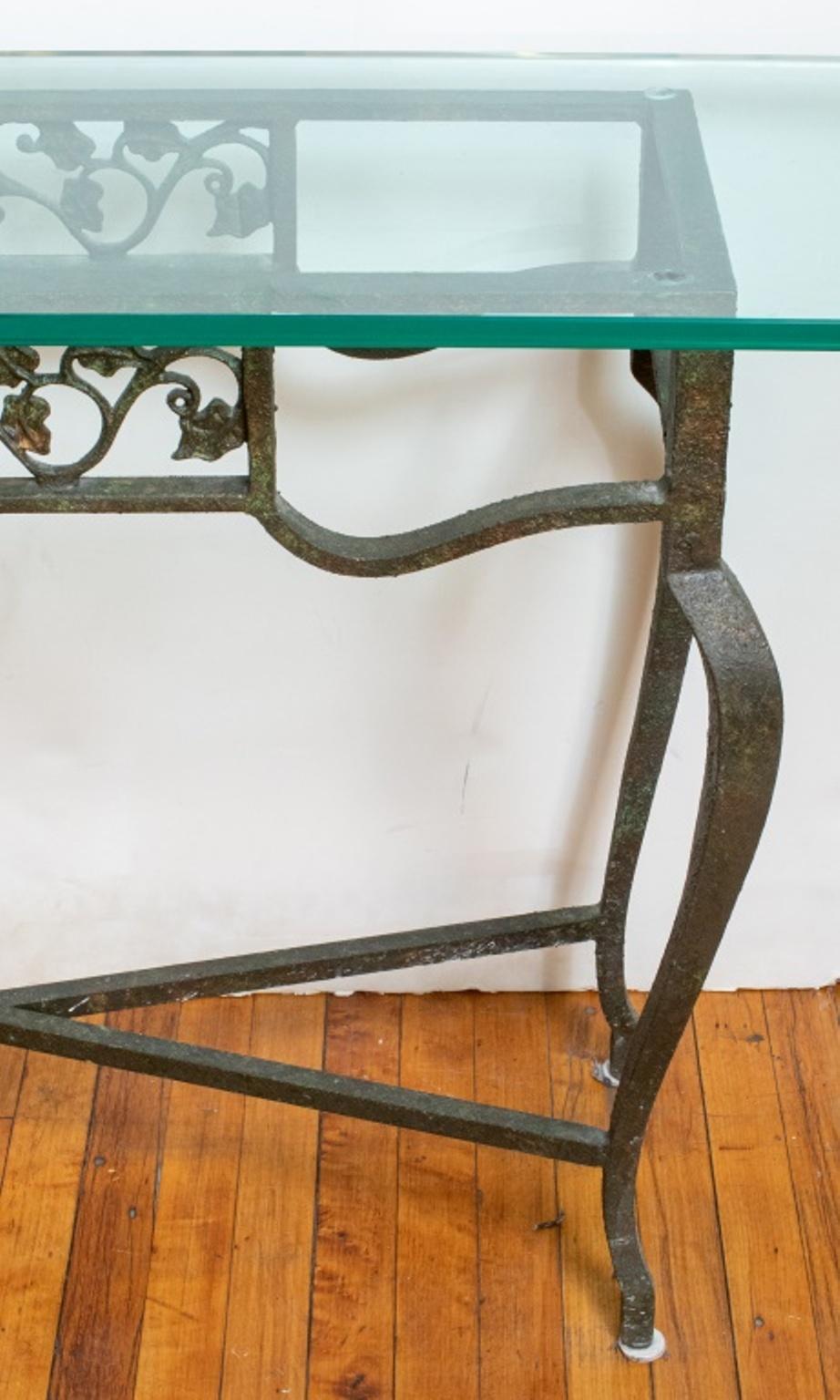 Patinated cast iron console table with a glass top. 
Measures: 30.5