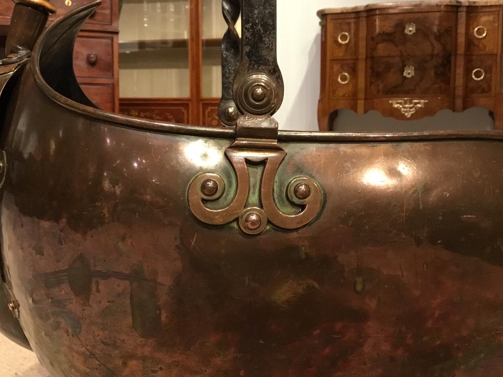 A patinated copper and iron Arts & Crafts Period coal scuttle. Having a wrought iron handle, patinated copper body and scoop. Supported on an Arts and Crafts inspired wrought iron base. Stamped RD 127757, England, circa 1890-1900

Dimensions: 21