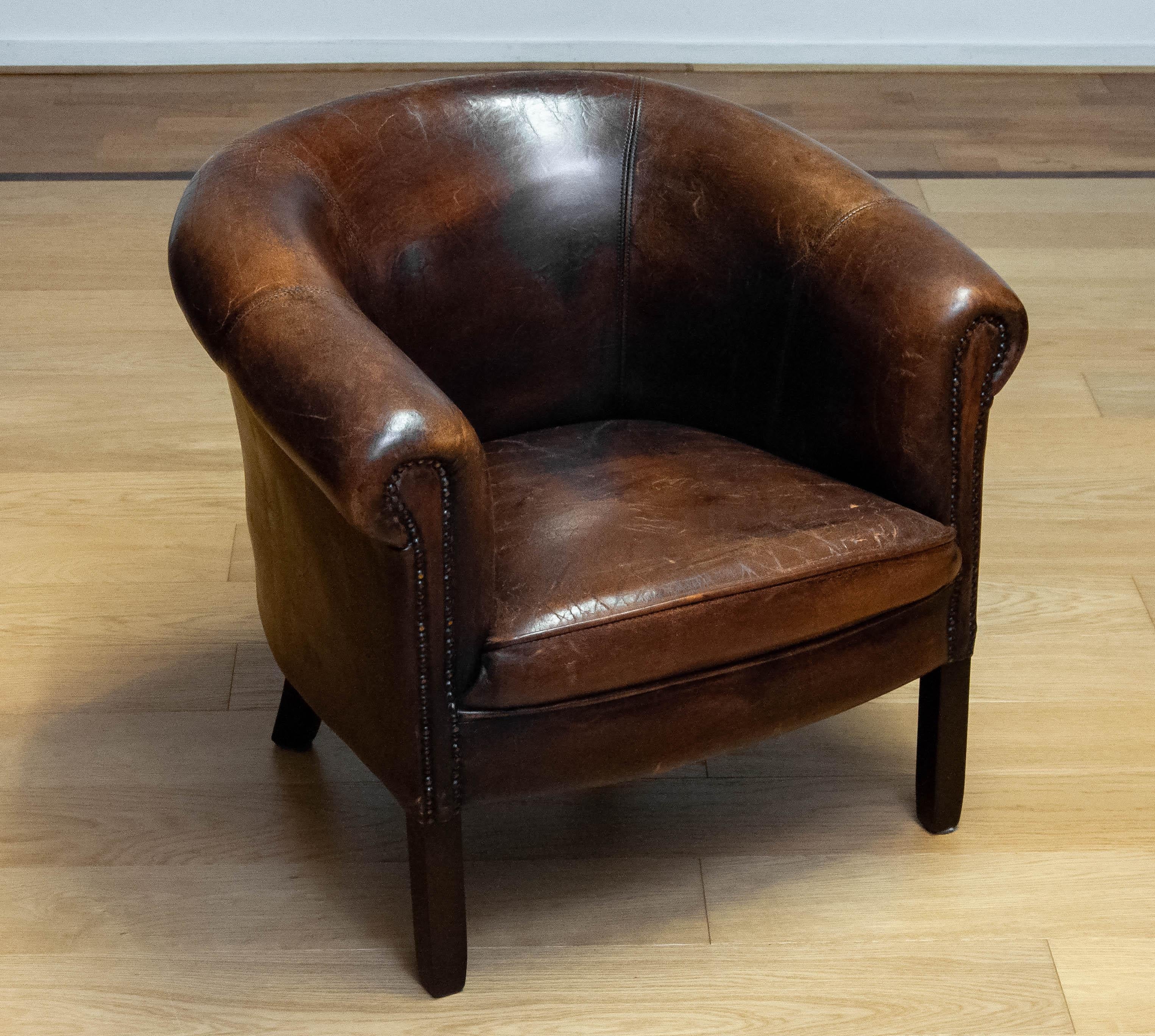 Characteristic and extremely decorative Dutch colonial arm chair upholstered with dark brown patinated tan sheepskin. Allover in good and comfortable condition and supports great.
