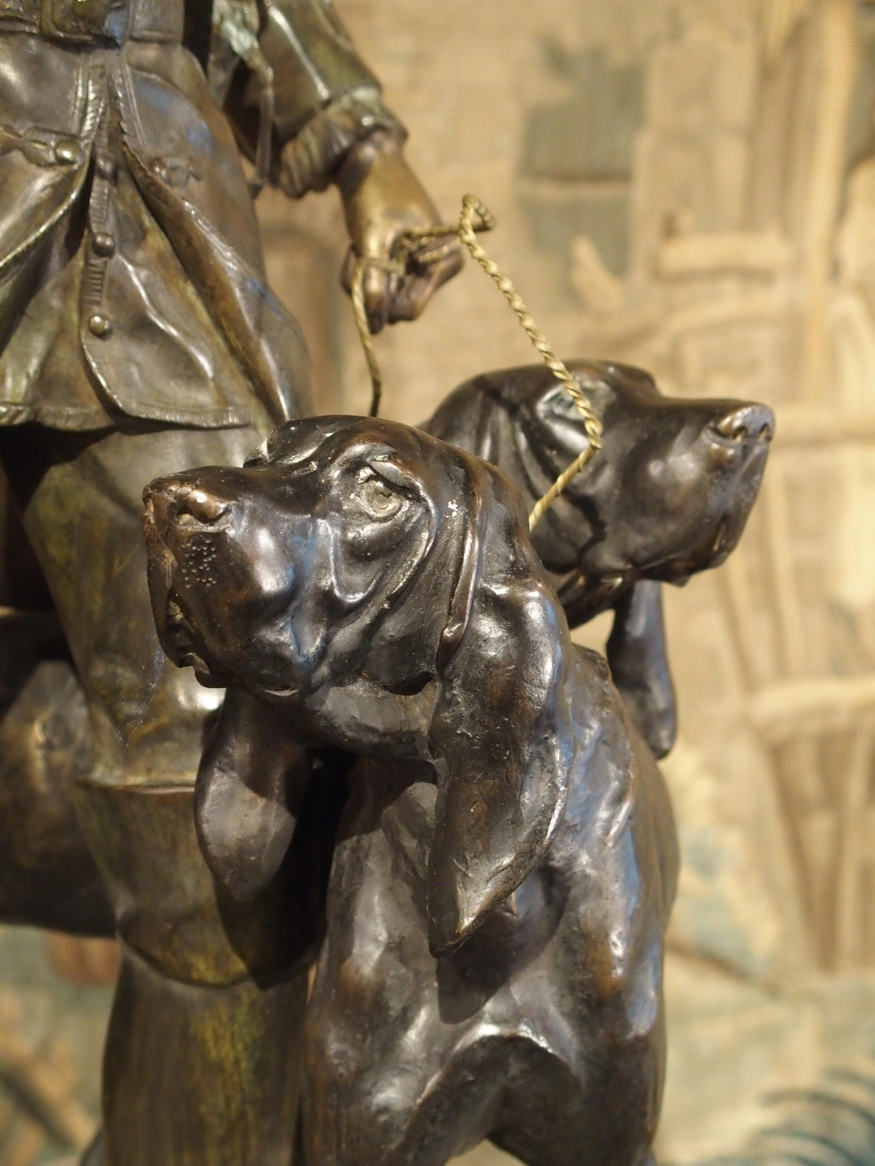 Statue française en bronze patiné représentant un chasseur et des chiens de chasse sur un piédestal en marbre 3