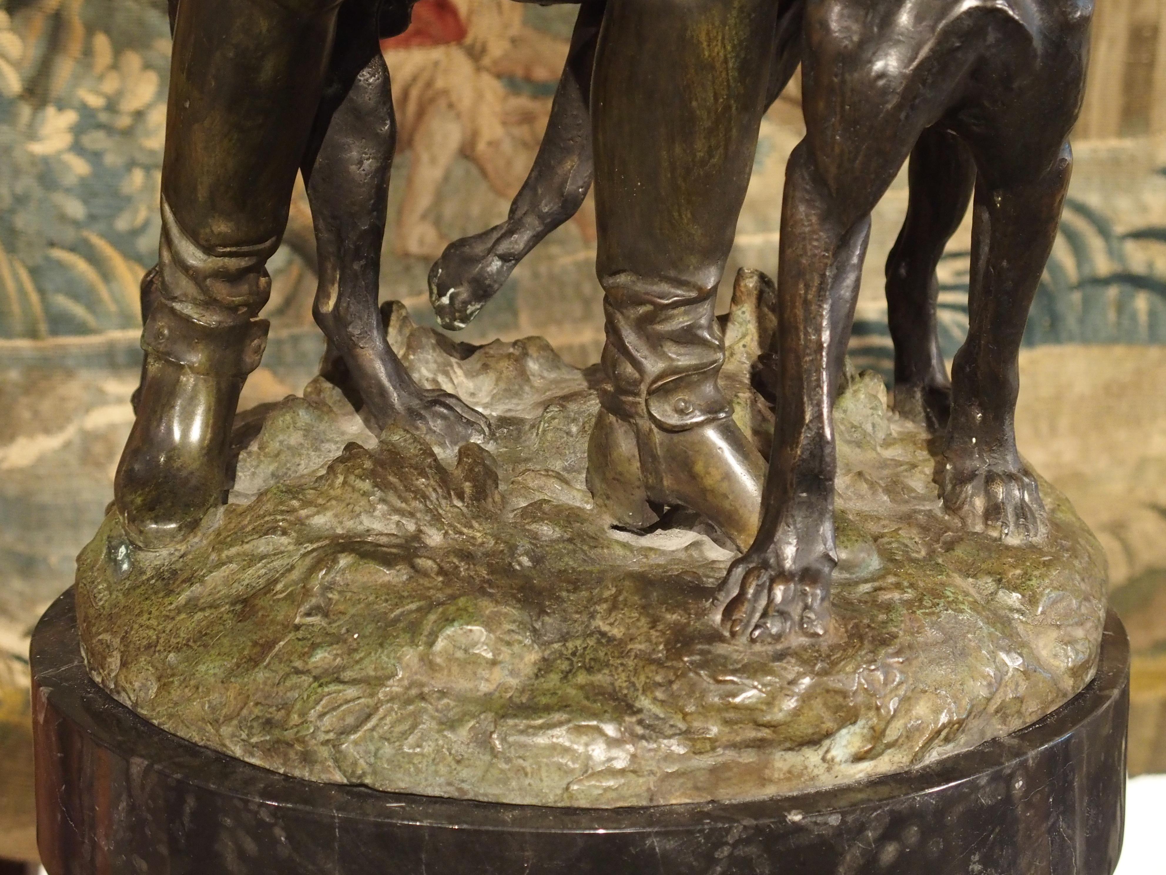 Statue française en bronze patiné représentant un chasseur et des chiens de chasse sur un piédestal en marbre 4