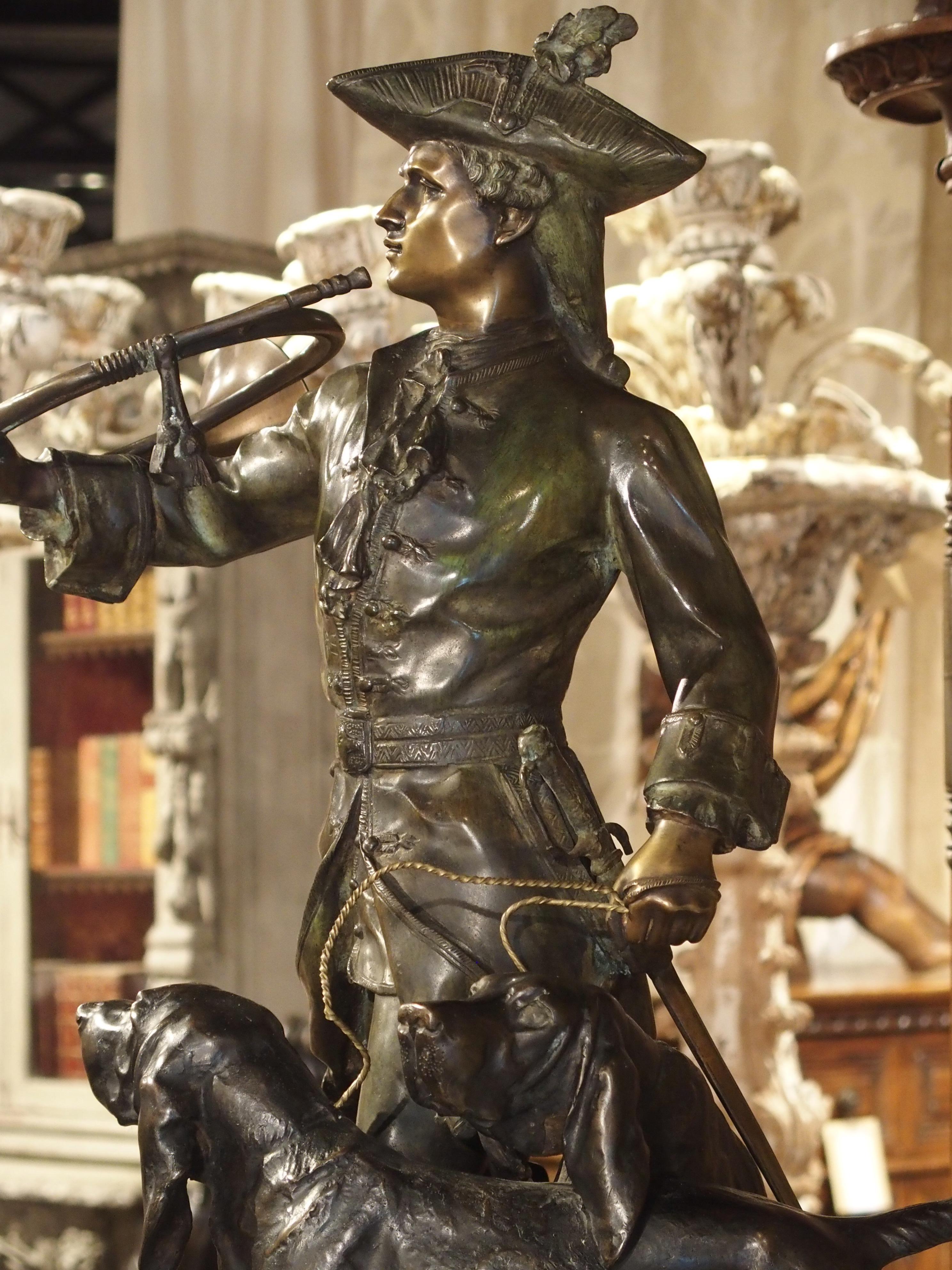 Statue française en bronze patiné représentant un chasseur et des chiens de chasse sur un piédestal en marbre 1