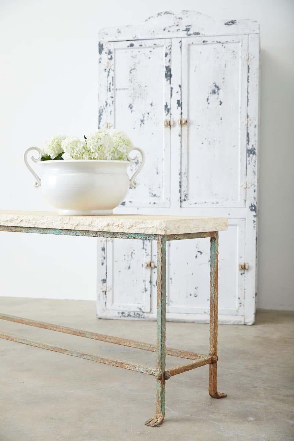 Amazing patio garden table or console table featuring a 2 inch thick stone top having a hand-chiseled live edge with a rough travertine style finish. The large iron base has a unique hand-hammered finish with small scalloped edges and ending with