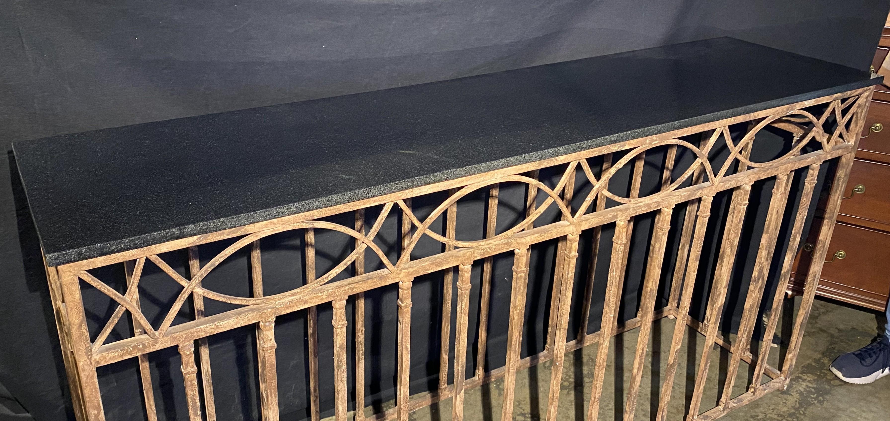 A solid patinated iron console table with fitted black marble top, perfect for any outside patio or for use in your entertainment room. Dates to the 20th century in very good overall condition, with great patina, light intentional surface rust, and