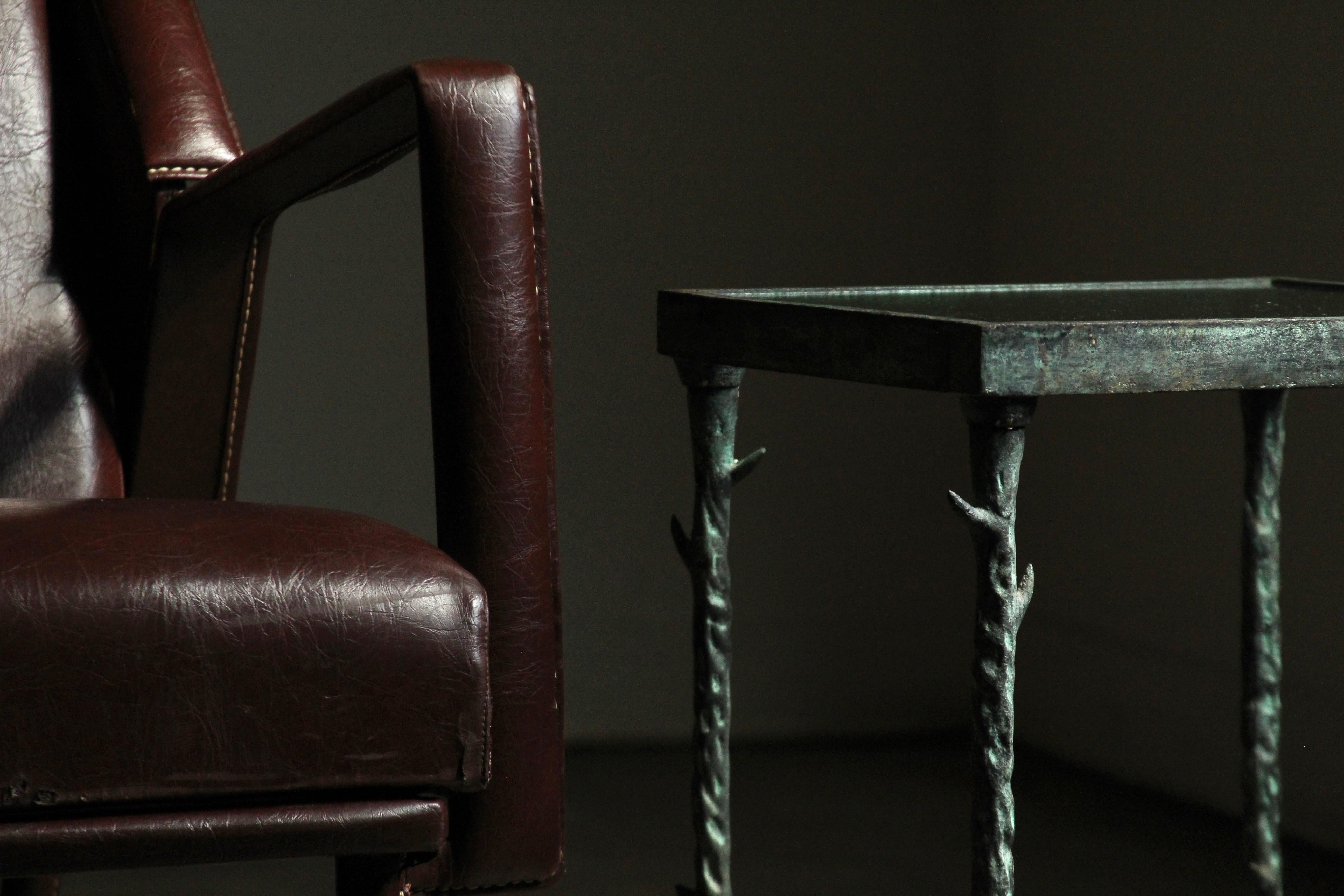 A stunning patinated iron accent table with glass top, handcrafted in the 1980s, and inspired by the work of Diego Giacometti. The table features thorned branches and a small bird. Beautiful verdigris patina throughout, and very nice craftsmanship.