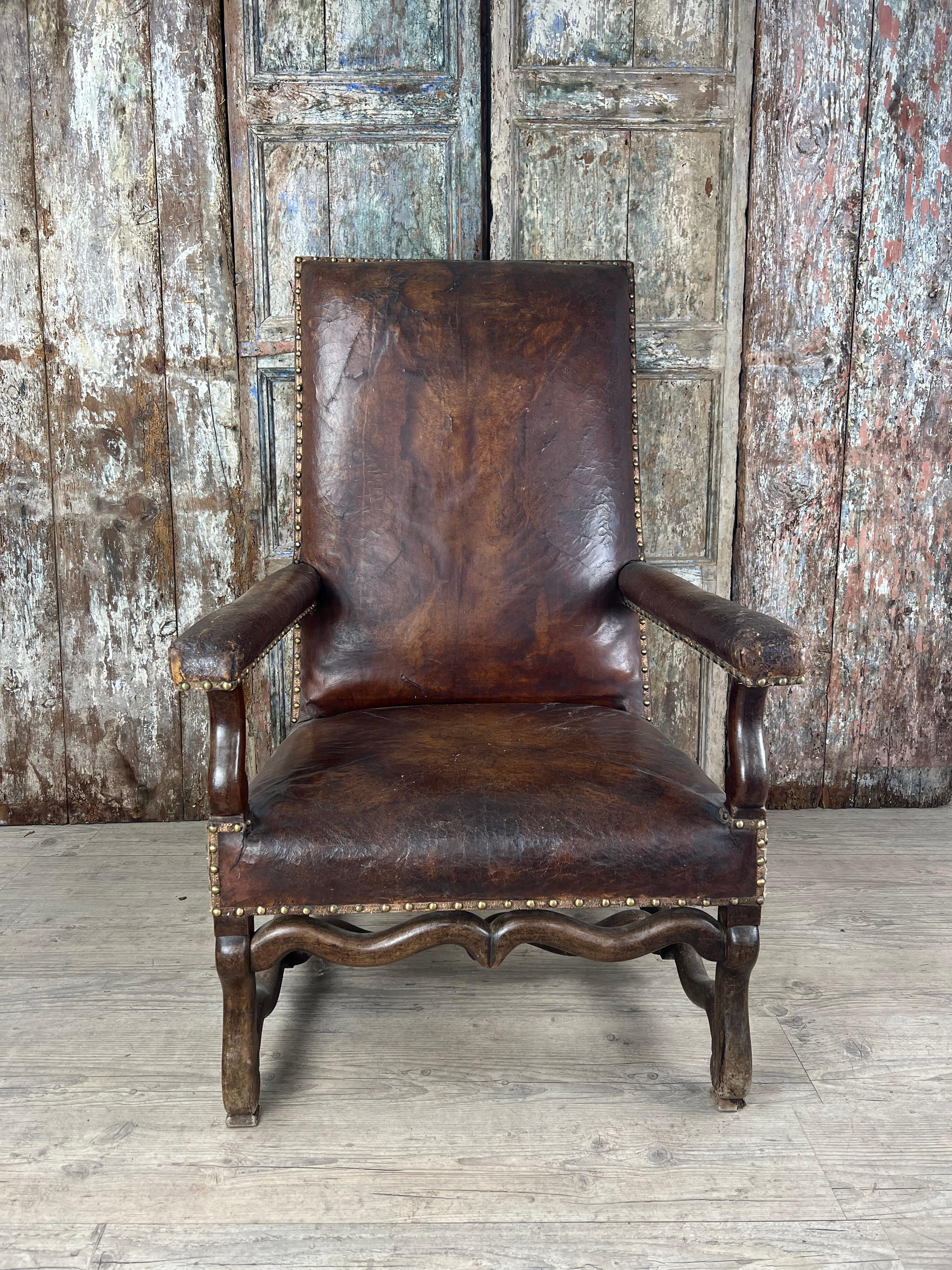 Majestic et chargé d'histoire, cet impressionnant fauteuil italien en cuir patiné, vers 1780, est une étonnante représentation du style Louis XIII. Fabriquée pour la distinction, son assise aux proportions généreuses est revêtue d'un cuir brun