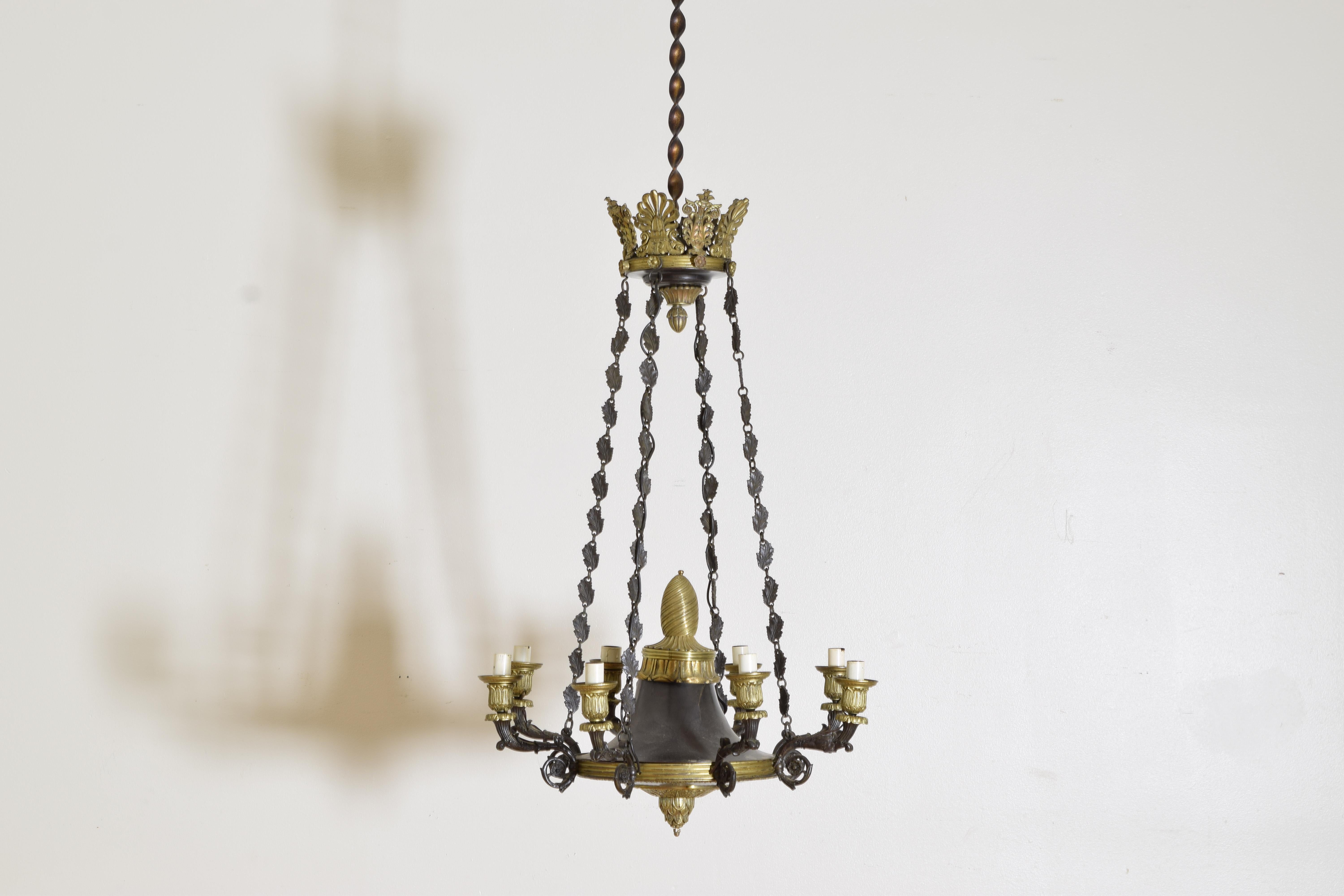 skillfully cast in brass with the center section a dark (nearly black) patinated metal with original canopy of acanthus leaves, original chains and a circular body with brass finial and terminal, the body issuing eight patinated brass arms 