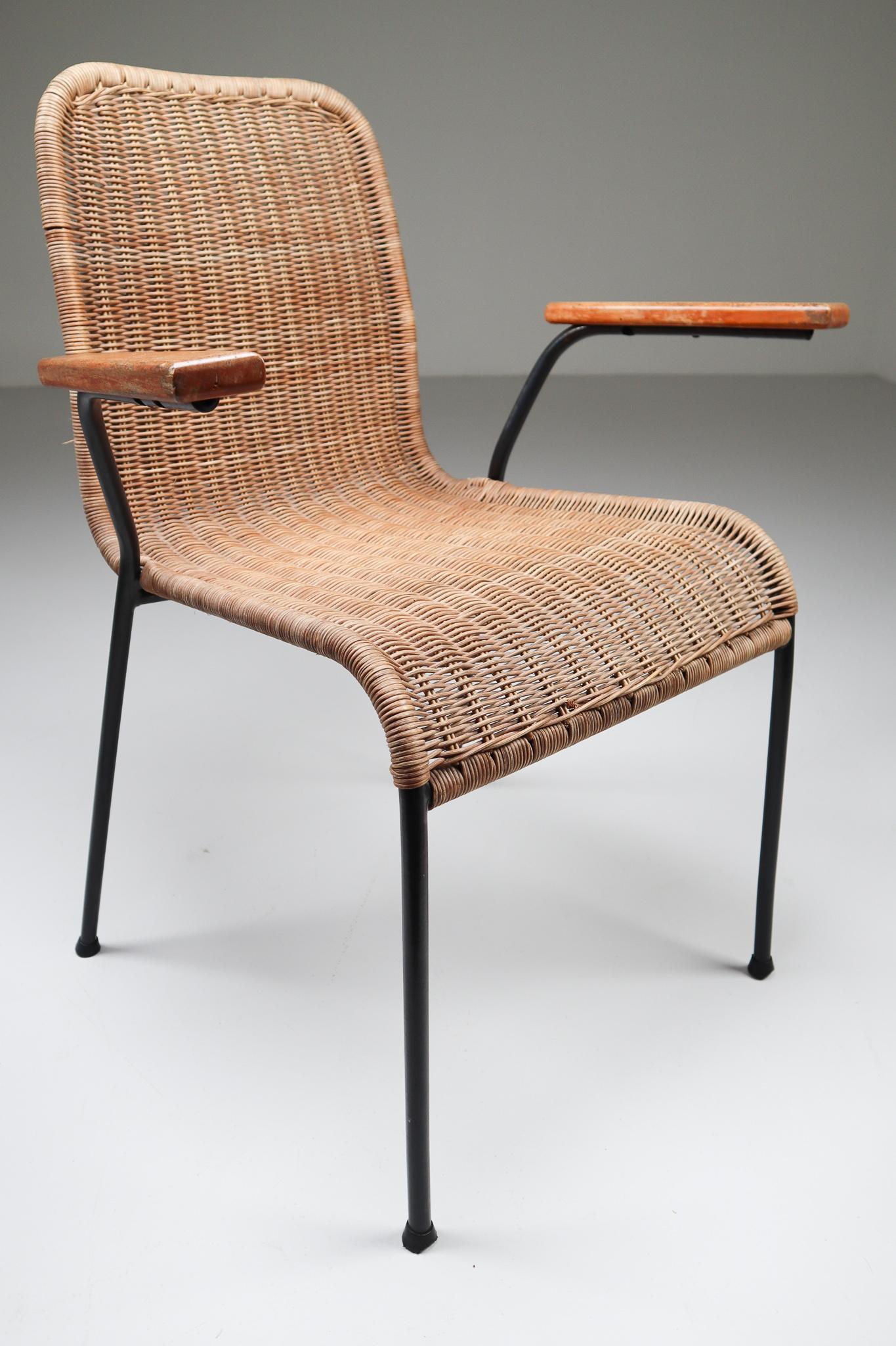 Patinated woven wicker midcentury armchairs designed and produced in The Netherlands during the 1950s. The chair is made from handwoven wicker for the seat and he frame is made of black lacquered steel. They are comfortable to sit in and create an