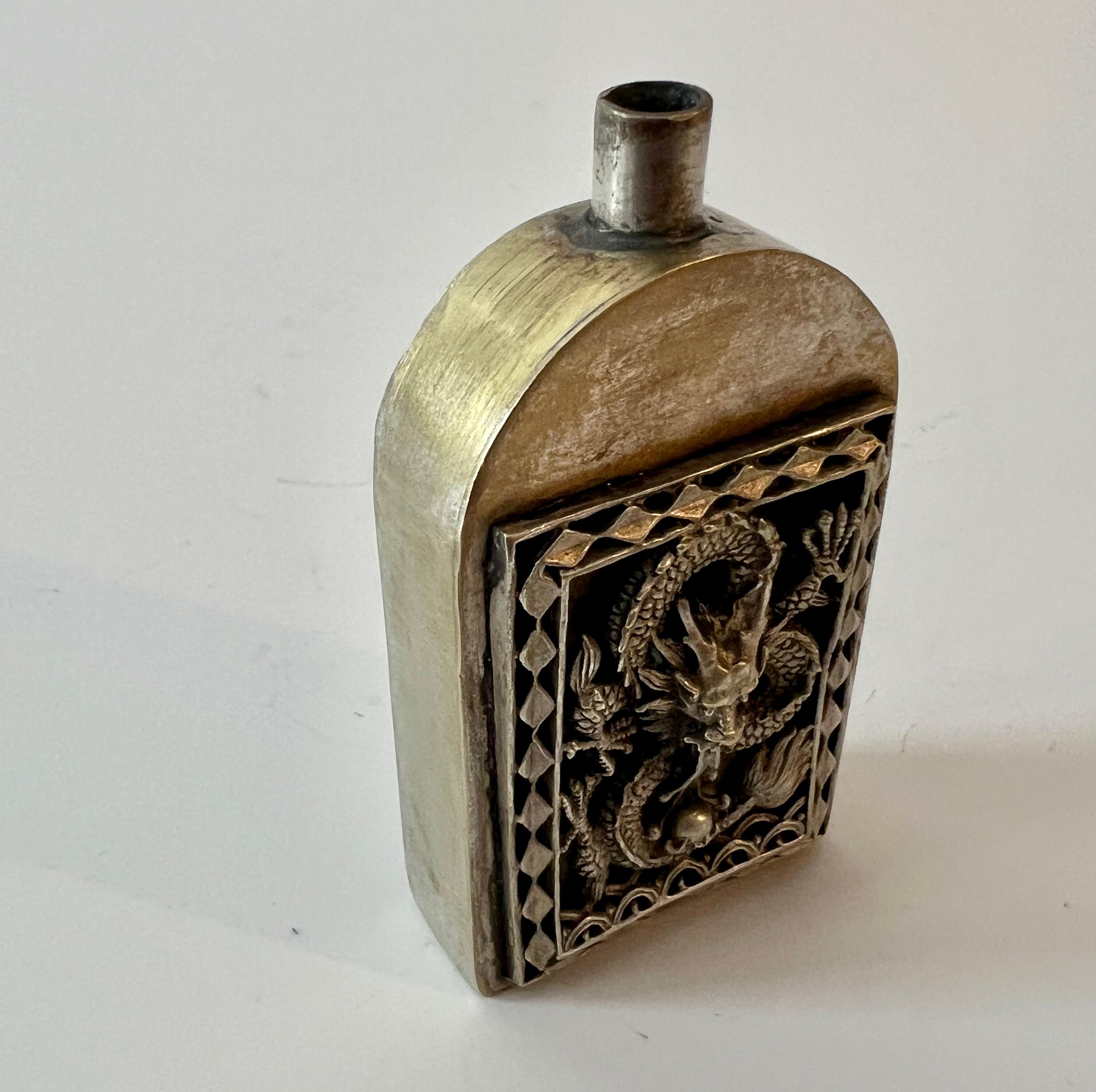 Maravilloso frasco de perfume chino de plata sin pulir con un dragón repujado... actualmente falta la parte superior, sin embargo es una pieza muy decorativa y una adición bienvenida a una colección o a un pequeño Altar.  

El dragón está tanto en
