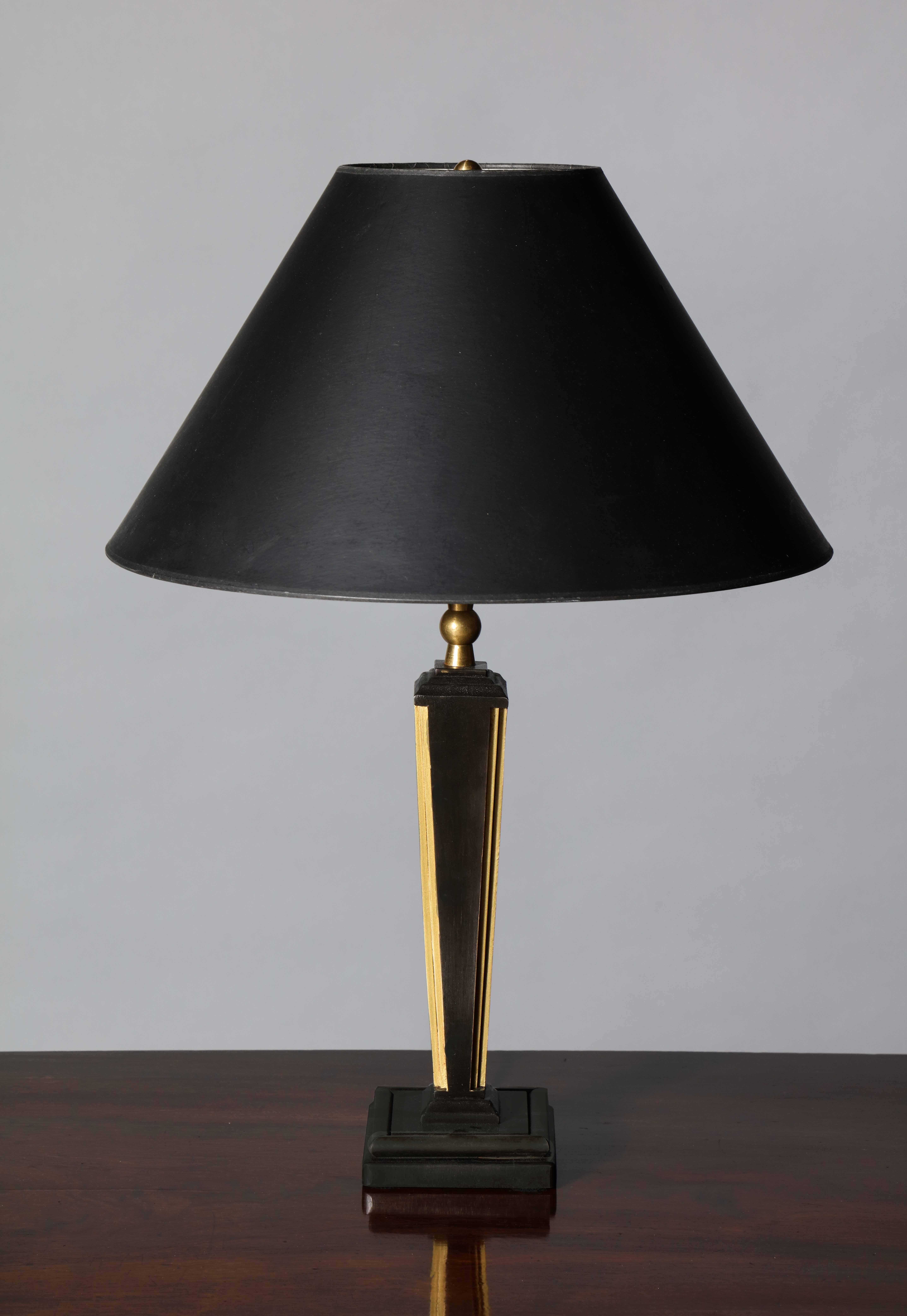 A handmade steel table lamp in tapered square form – set on a stepped square plinth. The form of this piece are heavily influenced by the mid-century French Neoclassical and Art Deco movements especially the fluting and tapers commonly depicted by
