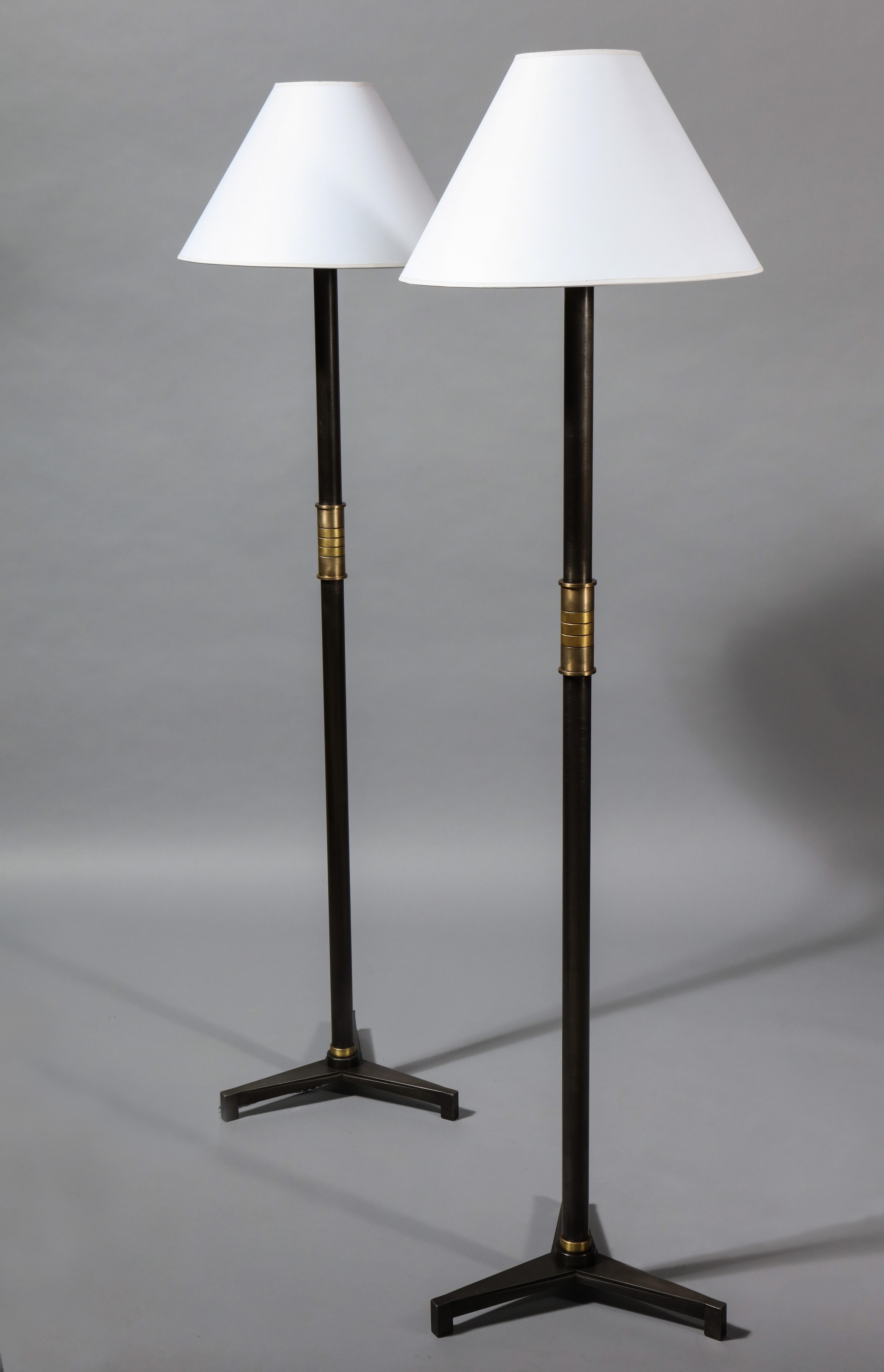 Eine Stehlampe mit dreifüßigem Sockel mit konischer Riffelung, die an die Art-Déco-Bewegung erinnert. Der Griff besteht aus einer Reihe von subtil kontrastierenden Messing- und Bronzebändern. Dieses Design ist auch von der französischen Neoklassik