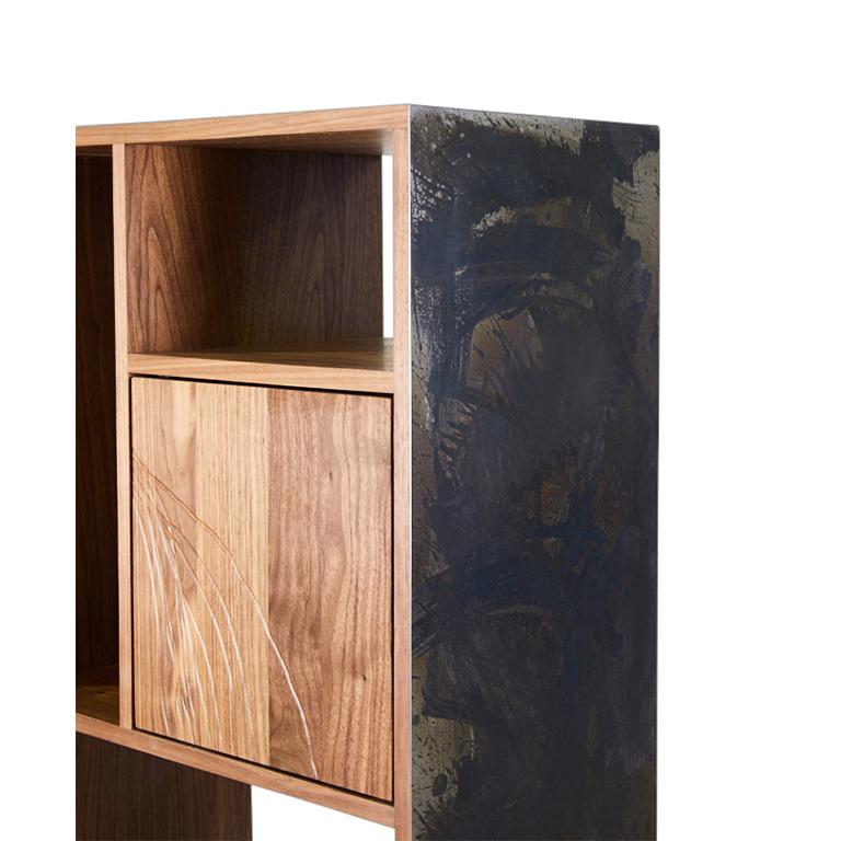 The E-1 is a dynamic étagère constructed from Walnut wood with a flame treated and patinated steel exterior. Three compartments, two doors and one drawer, feature Walnut wood faces with abstract line drawing etched into the wood. All hardware is