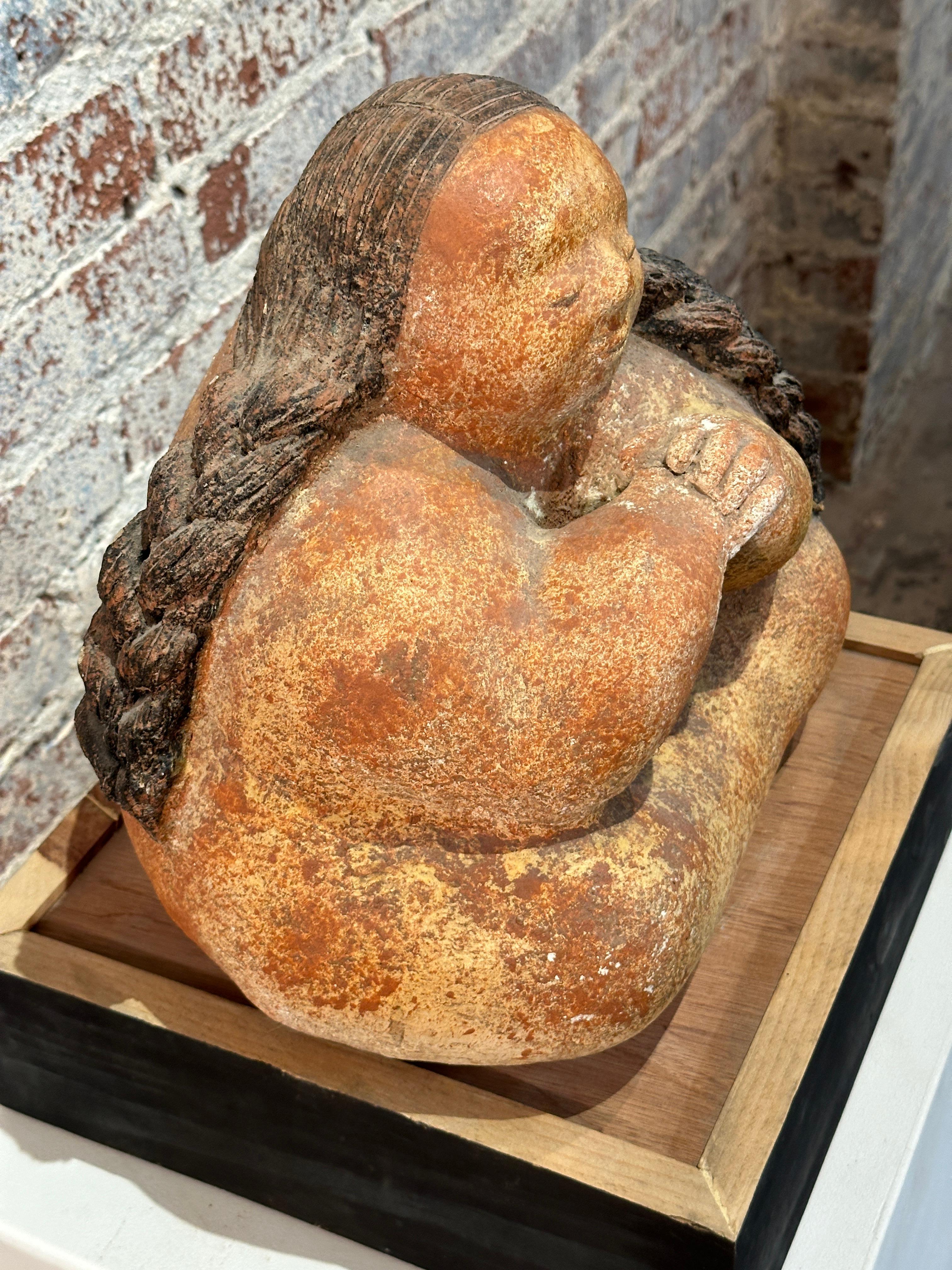 Cette statue représente une jeune fille captivante, assise dans une méditation sereine, sculptée dans de la pierre pyrophyllite. La sculpture est empreinte de douceur et de spiritualité.

Ses deux longues tresses sombres encadrent son visage