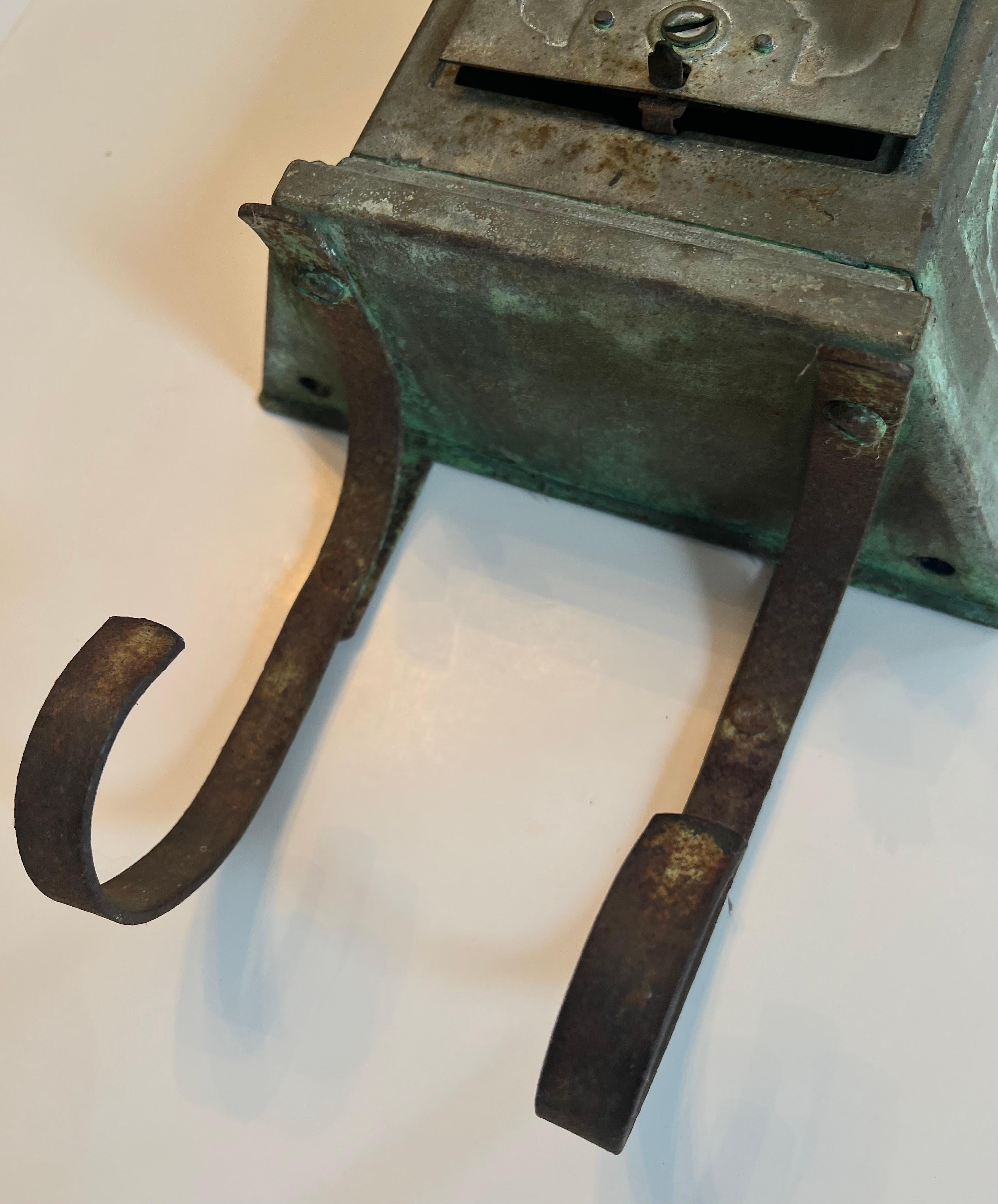 A wonderfully patinated metal mail or letter box with cradle for newspaper and larger pieces of mail.

The piece has a slit in the top to add mail, and a front door to retrieve new pieces.  The patinated finish is wonderful and rich.    A compliment