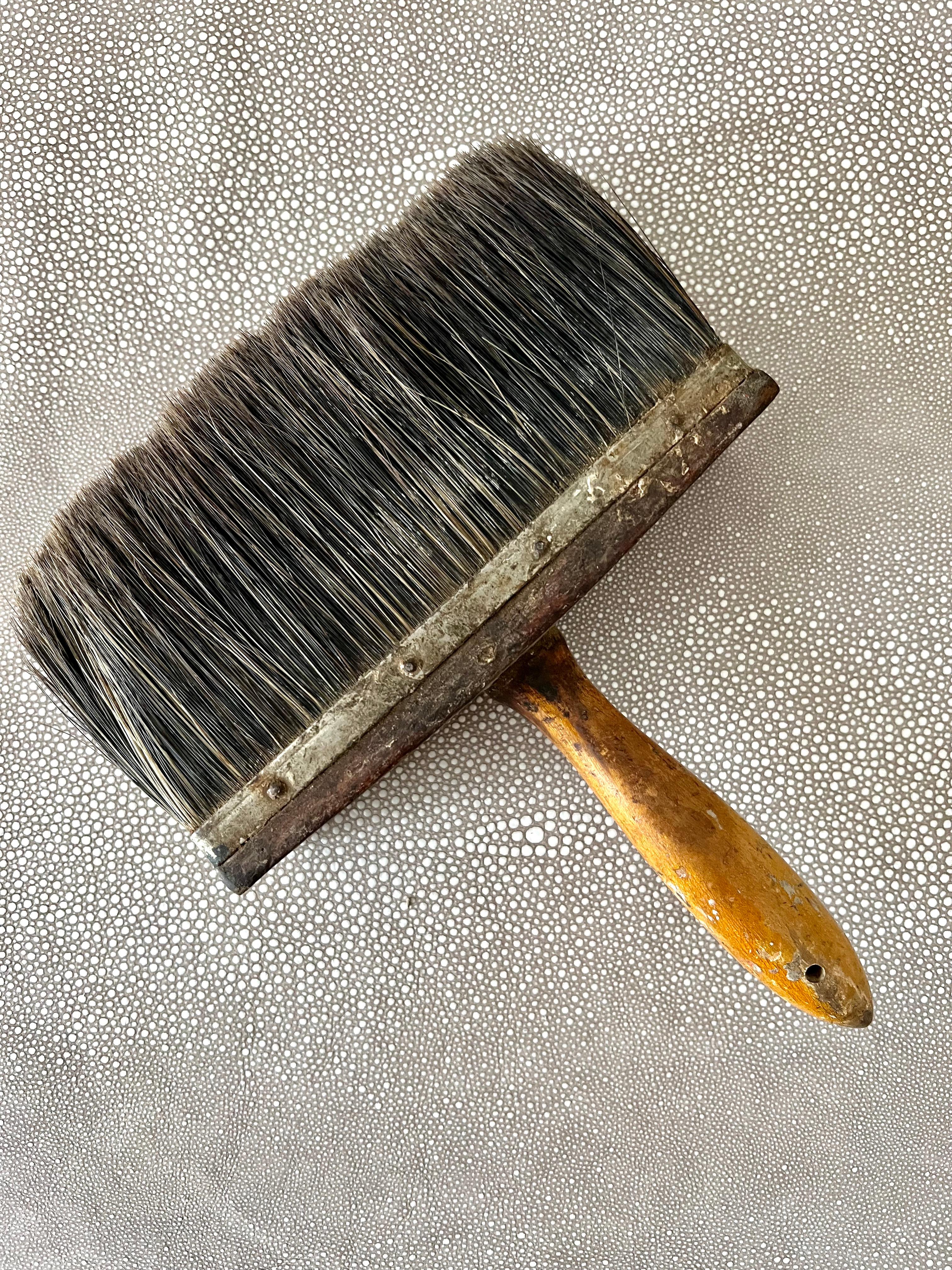 A vintage paint brush - patinated and full of life and stories... a wonderful decorative piece for any room - organic and textured. The wood is thick and substantial - with a band of metal and finishing nails to hold in the horse hair bristles...