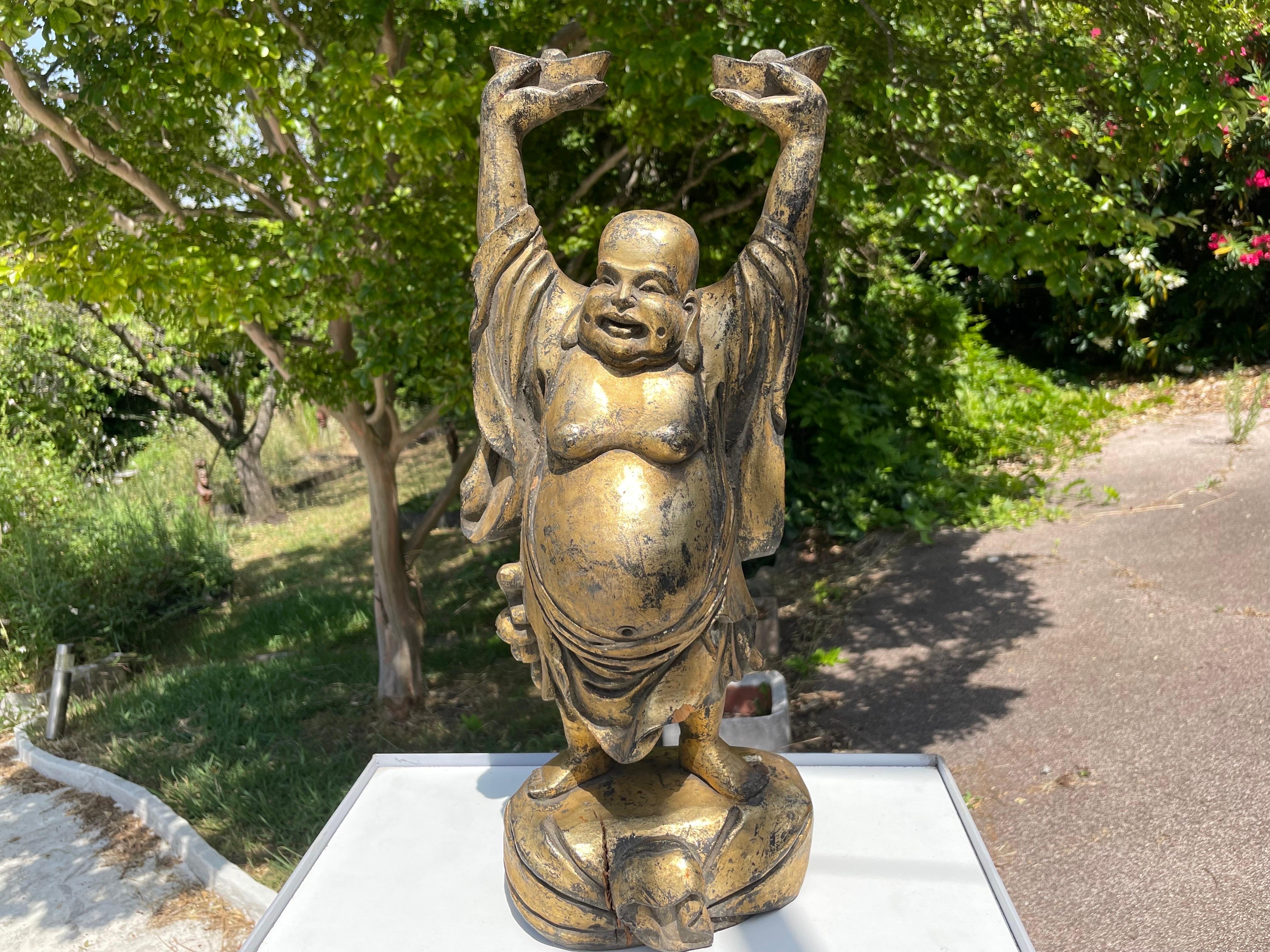 Sculpture in patinated wood, representing Buddha, made in China at the beginning of the 20th century. Buddha is depicted with his arms raised. The gold leaf with which it is covered, provides a very beautiful patina, and a pleasant shine. The