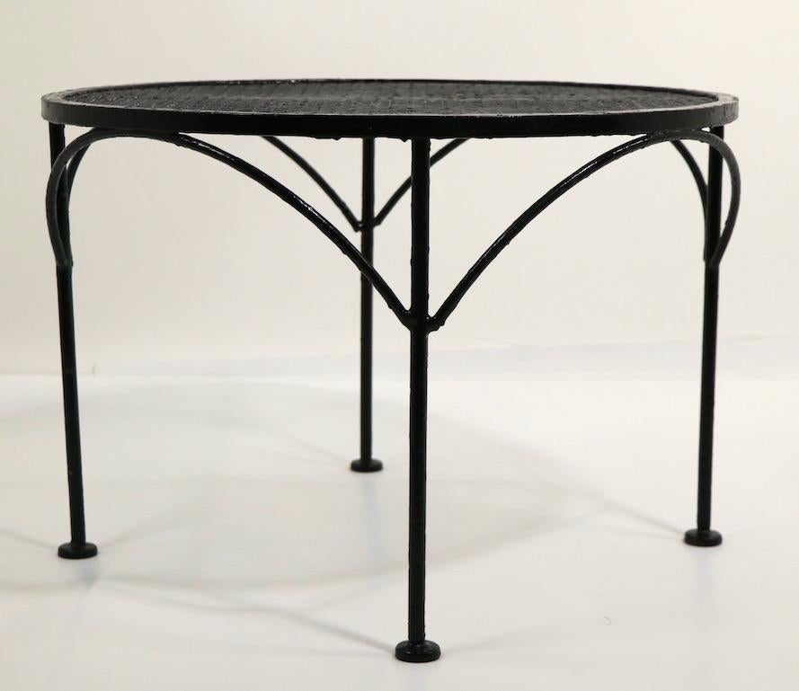 Diminutive occasional, end or side table attributed to Salterini. The table has a metal mesh top, and wrought iron legs, with decorative arched corbels. This example is currently in later black paint finish. Please view our extensive collection of