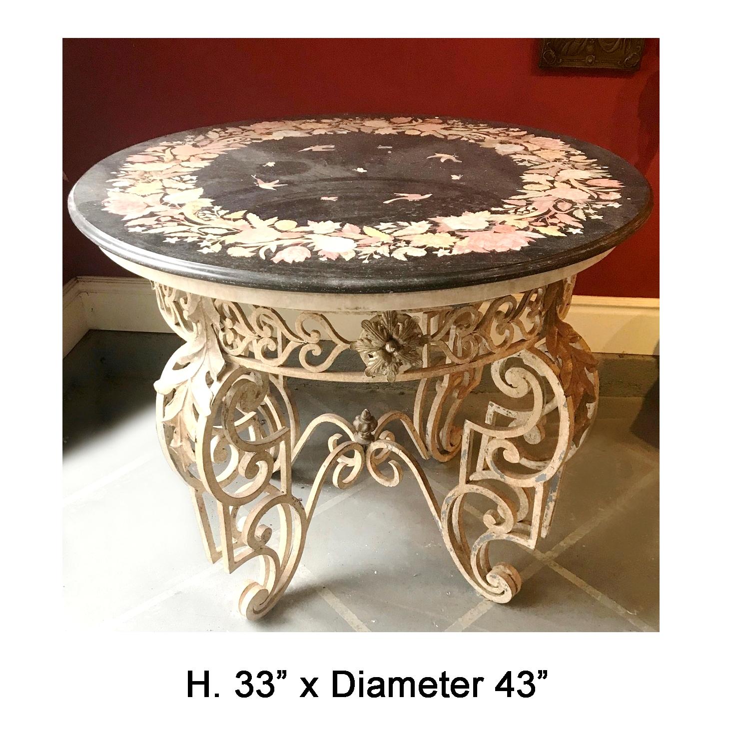 Attractive Italian hand forged wrought iron painted round table with beautiful inlaid marble top. 
The black marble top inlaid with variegated marble in flower, leaf, and bird motif resting on leaf design four legged round table. 
The table would