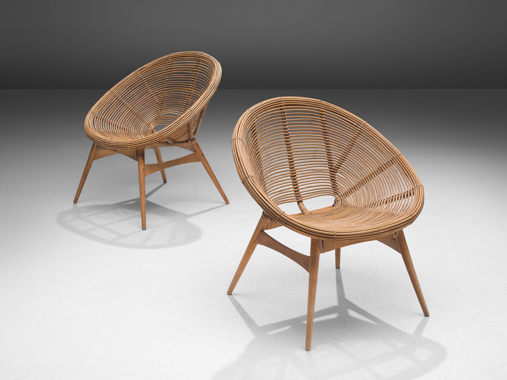 Lounge chairs, bamboo, wood, Europe, 1960s

Lovely pair of lounge chairs with an organic appeal characterized by an open, basket-shaped seat executed in woven bamboo. The minimal looking base is comprised of round, contoured tapered feet in wood.
