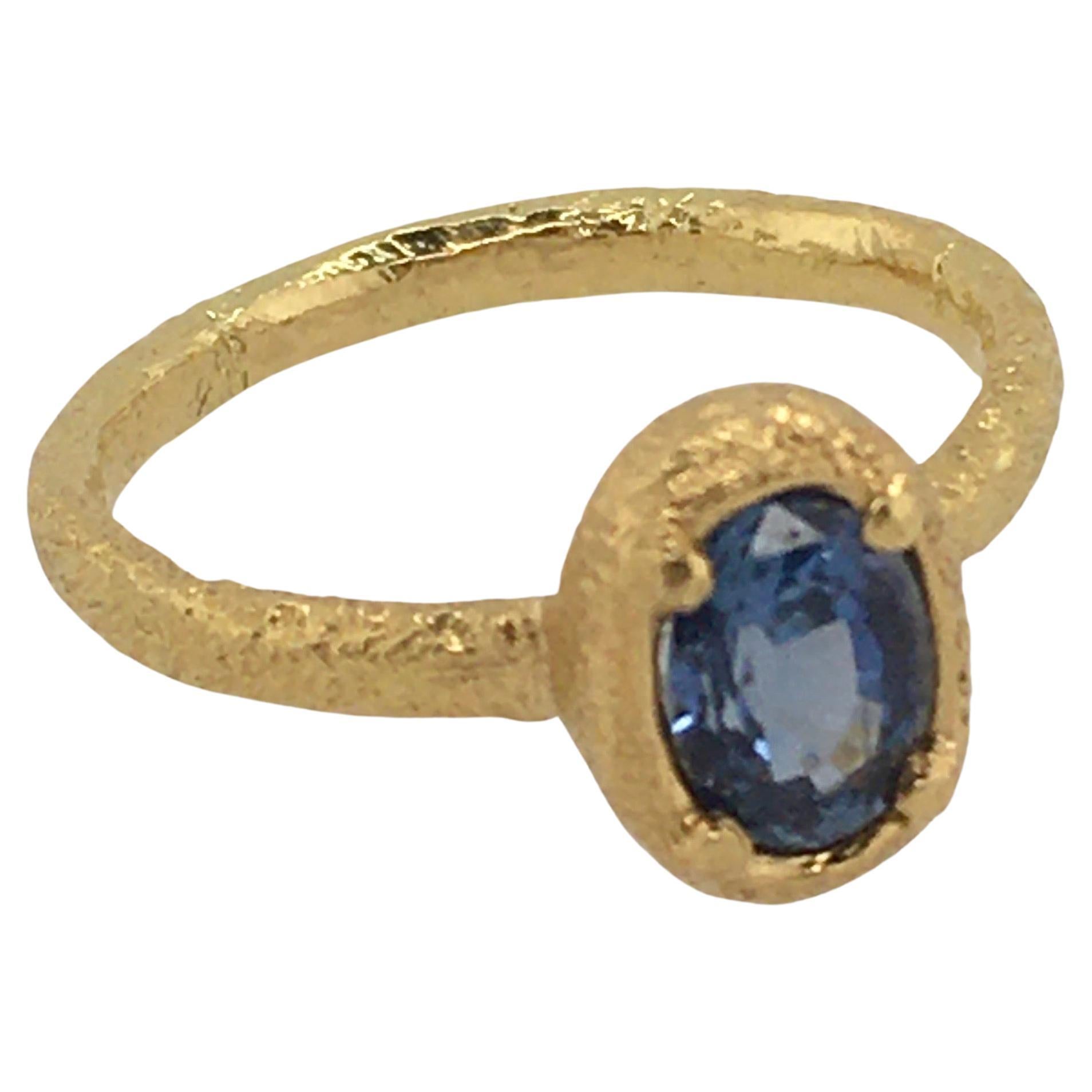 Stunning one-of-a-kind oval Ceylon Blue Sapphire set in hand-textured 18K Yellow Gold.  Sapphire measures 6.82mm x 5mm x 3.46mm.  The band width is 2.5mm.   Created by well-known Portland, Maine jeweler Patricia Daunis.   

Part of her custom 18K