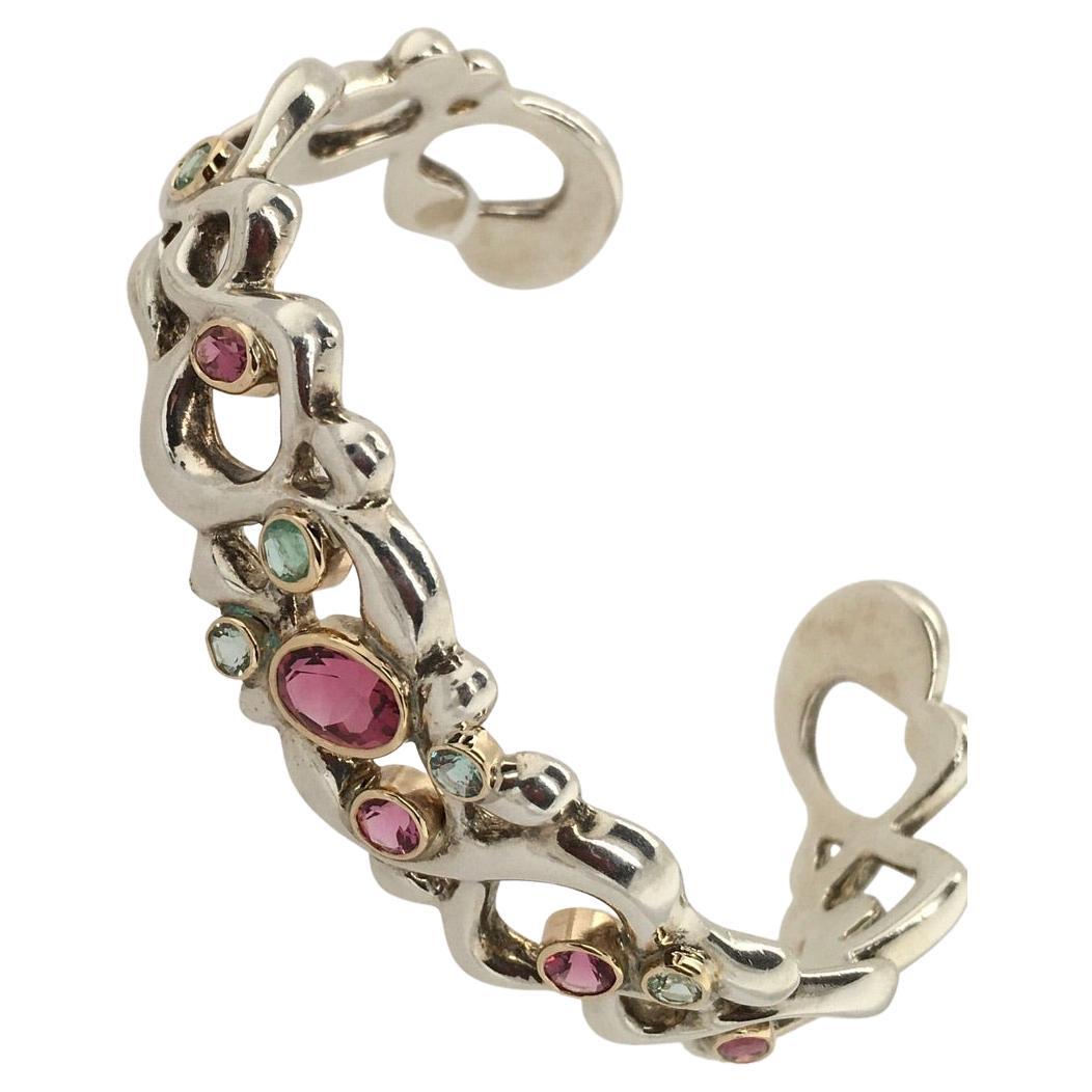 One-of-a-kind Cuff Bracelet designed and created by celebrated Maine jeweler, Patricia Daunis in her Portland studio.  Oval and round Pink Tourmaline and Green Beryl gemstones set in 18K Yellow Gold bezels adorn this highly polished Sterling Silver