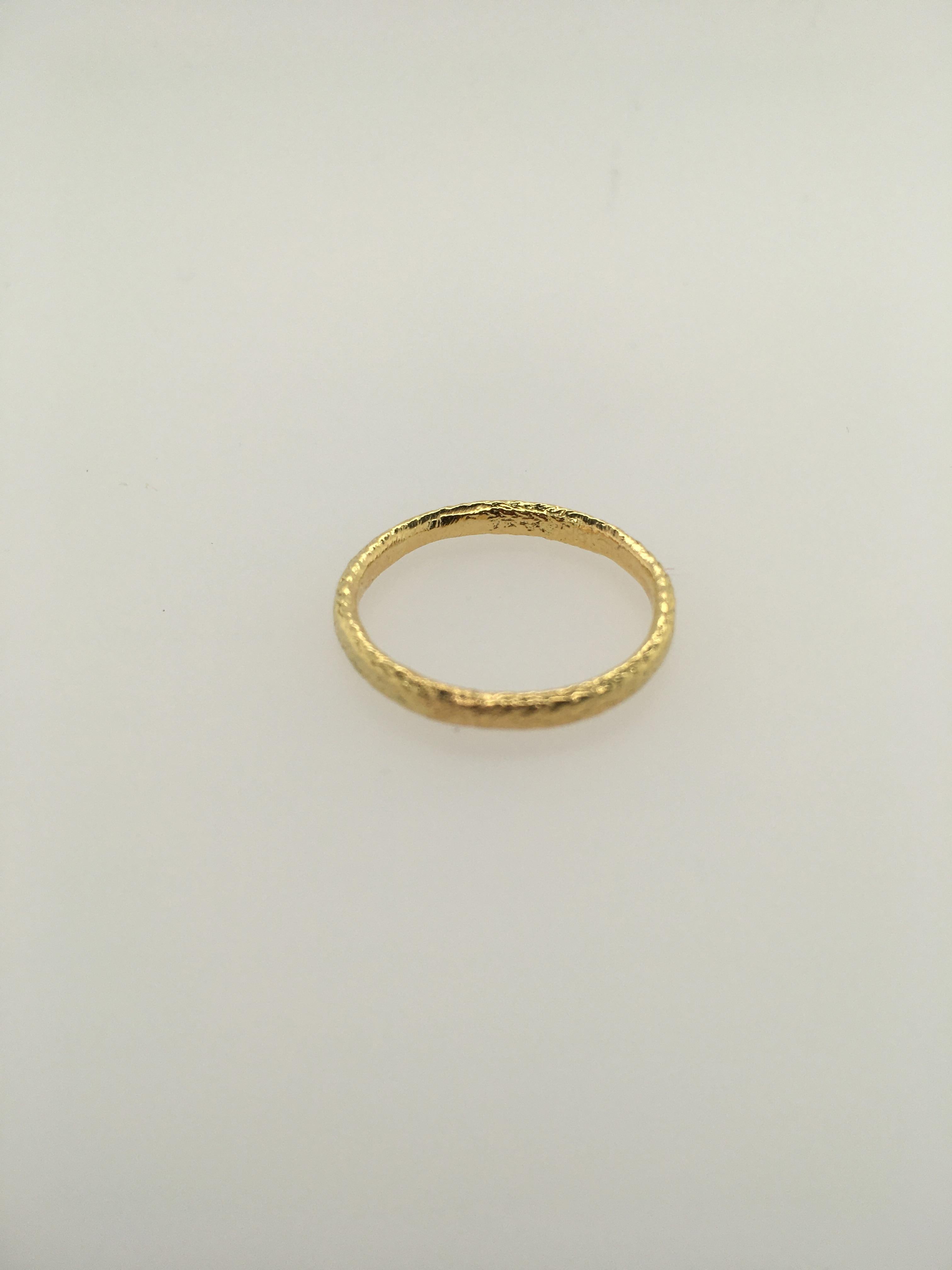 18K Yellow Gold hand-textured, slightly domed wedding band by well-known Maine jeweler Patricia Daunis.  Band measures 2.5 mm.  Ring size is 6.5.  This simple, striking band is part of a custom Daunis ATUIK collection of 18K textured rings. It