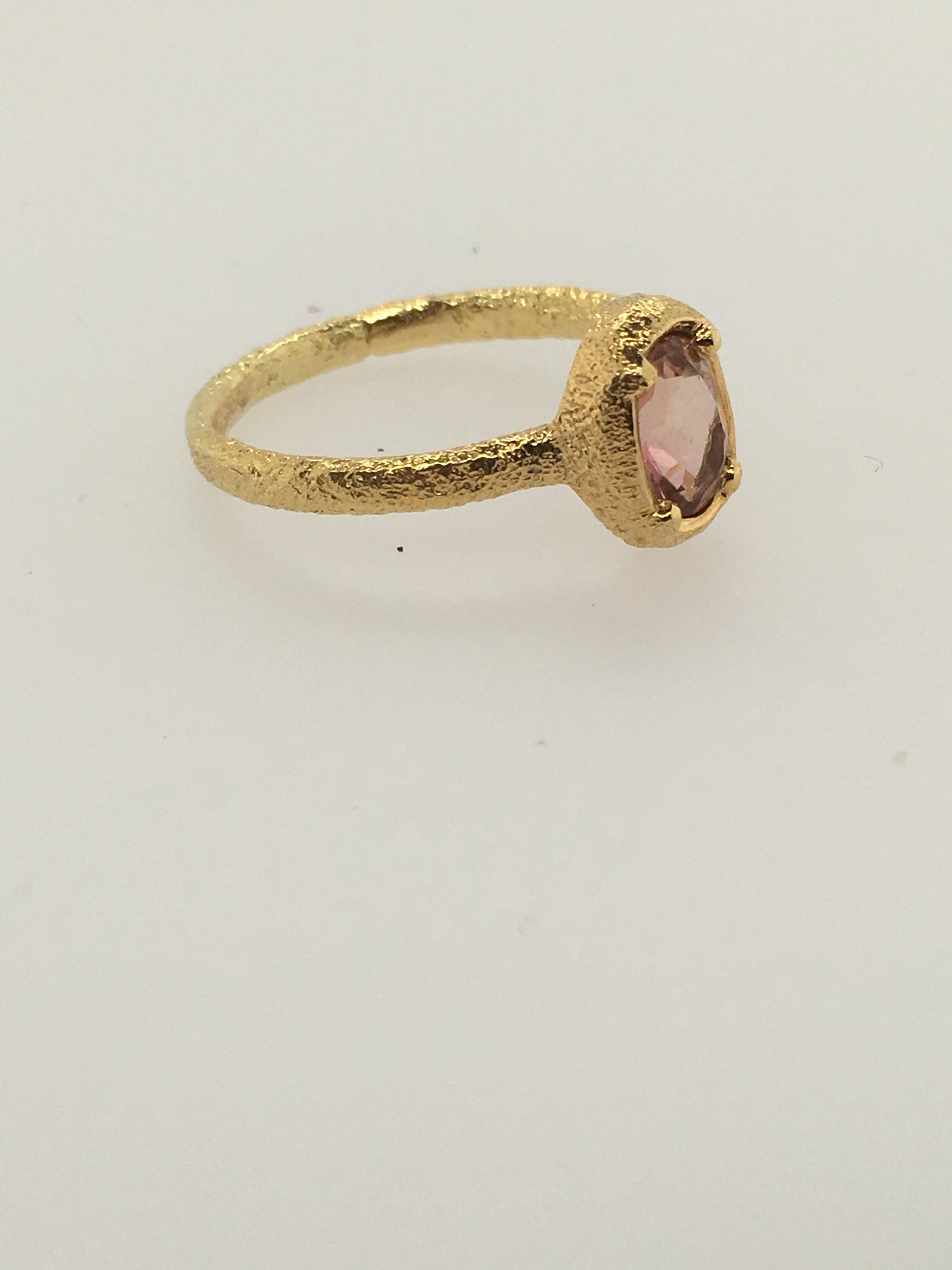 Lovely hammered 18K Yellow Gold Ring with oval Peach Tourmaline. Tourmaline measures 7 mm x 5 mm.  Hand-fabricated by well-known Maine jeweler, Patricia Daunis in her Portland studio.   Part of her custom 18K Yellow Gold ATUIK collection, this ring