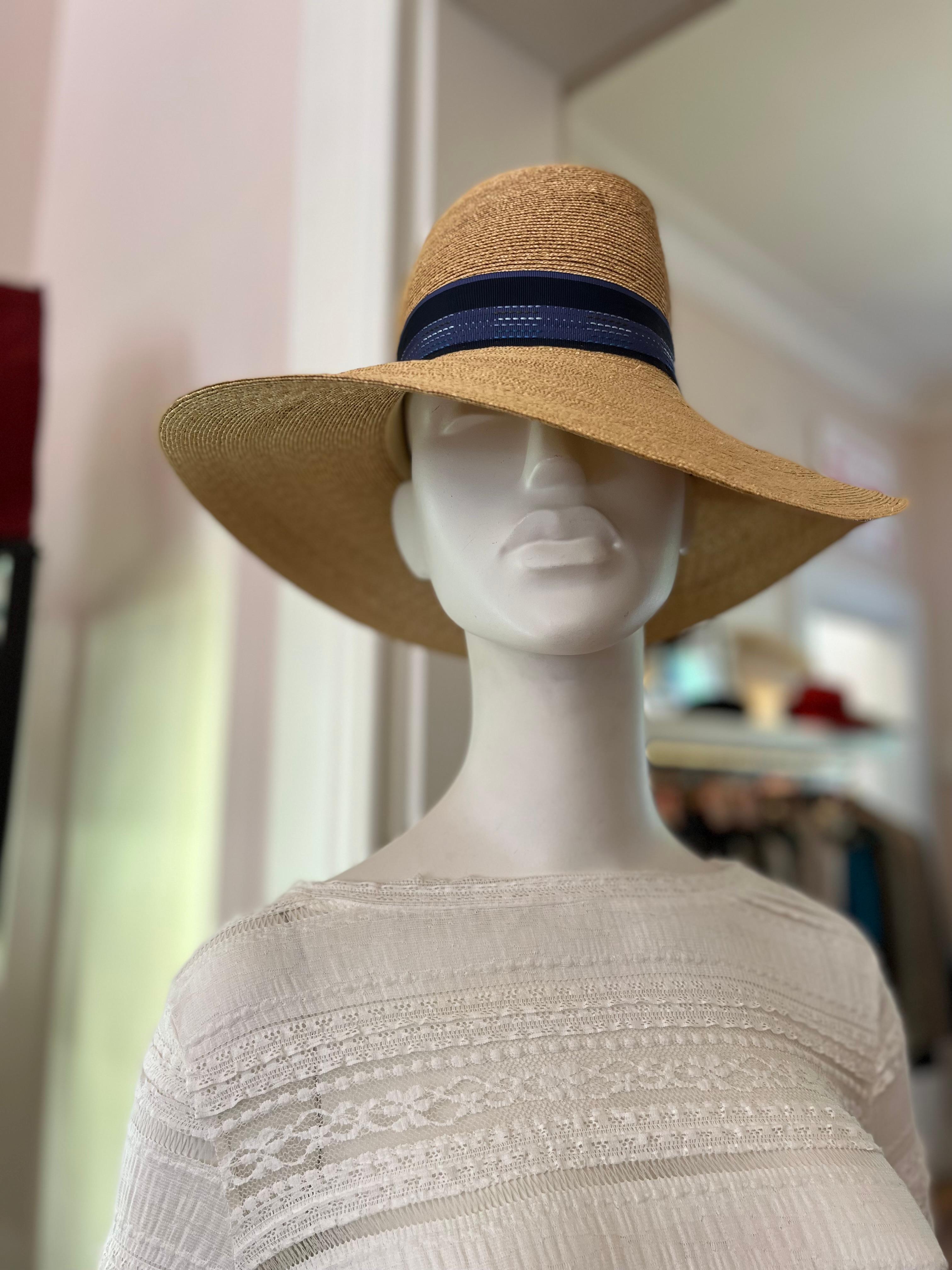 This is one of British Milliner Patricia Underwood's Iconic hats. Straw with an undulating brim and a gros grain blue and black band.
Perfect hat for both protection and style.