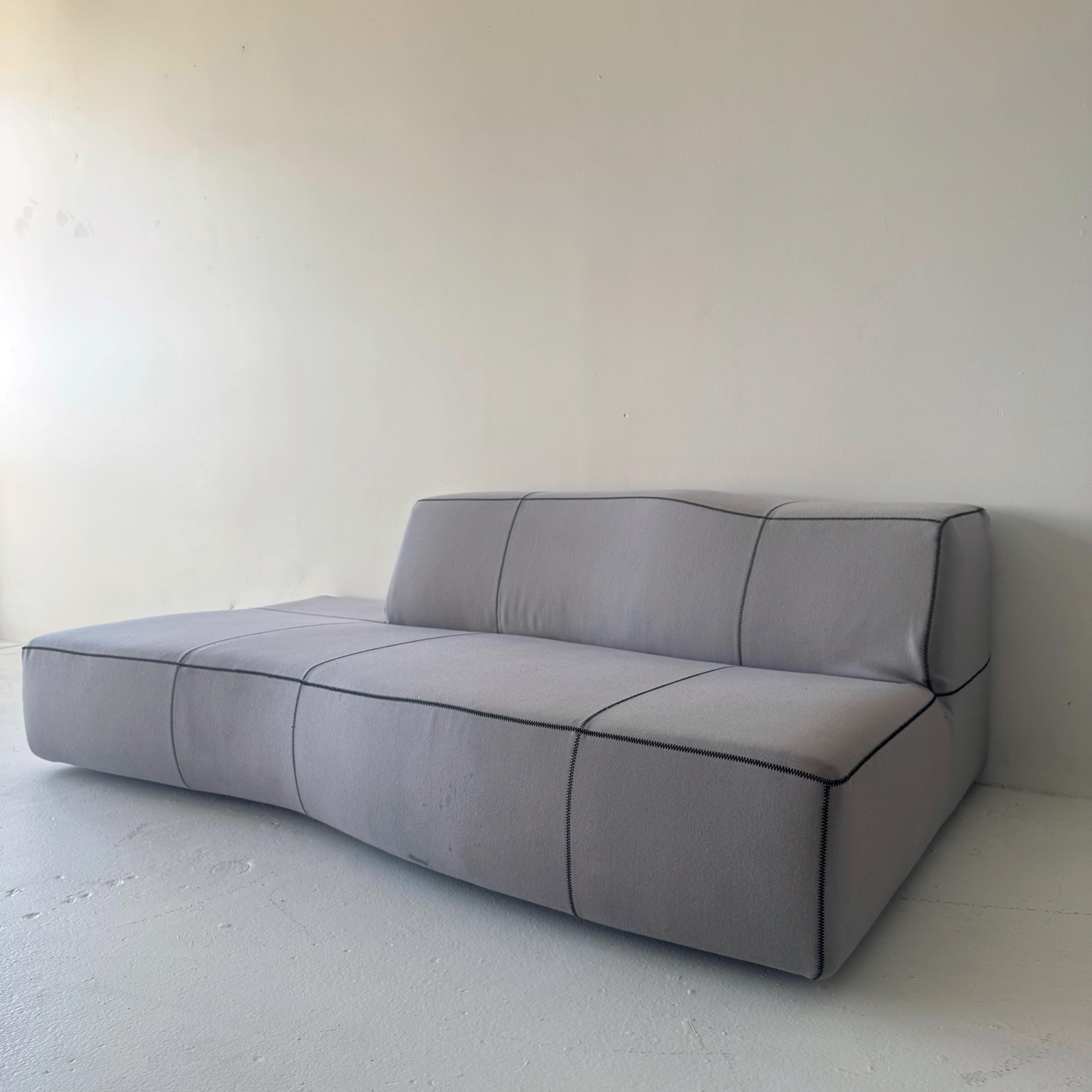 Patricia Urquiola para B&B Italia Sofá seccional Bend. Un diseño escultural y biomórfico que equilibra la comodidad con la forma arquitectónica. Tapizado en suave tejido gris con las características costuras irregulares que dan al Bend su perfil