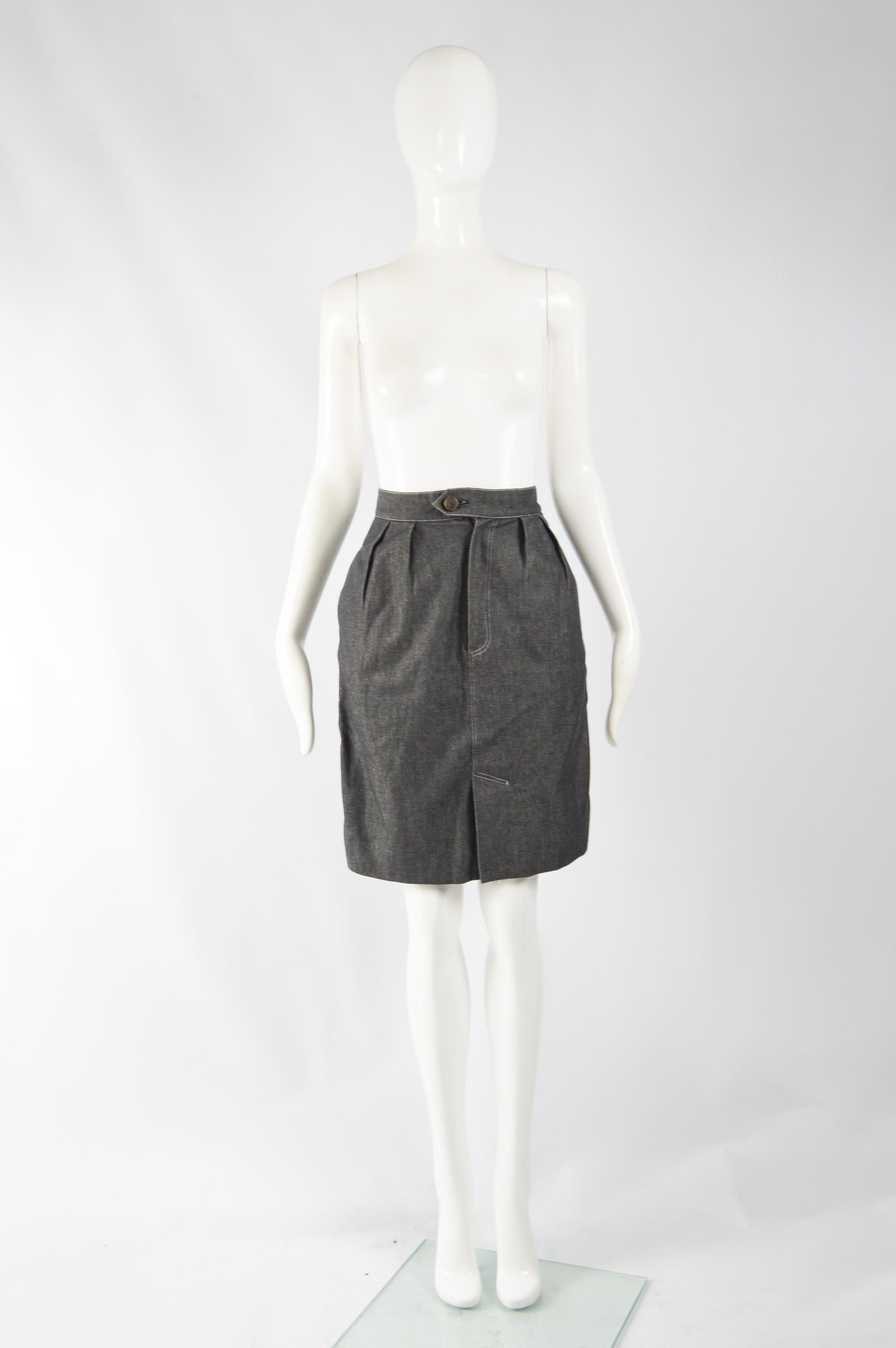 A cute vintage high waisted, lined jeans skirt from 80s by legendary fashion designer, Patrick Kelly. In a grey denim with darts at the waist to make the hips flare out slightly and make a flattering hourglass shape. It has a black grosgrain stripe