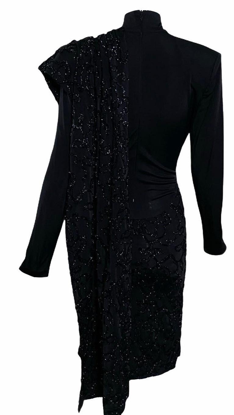 OMG. This Patrick Kelly dress is everything. Lightweight black jersey with mock turtleneck and lightly padded shoulders. Unlined and slightly sheer. Stitched on eyelash lurex sguiggle on giant flounce that wraps over bodice and draped in back. Can