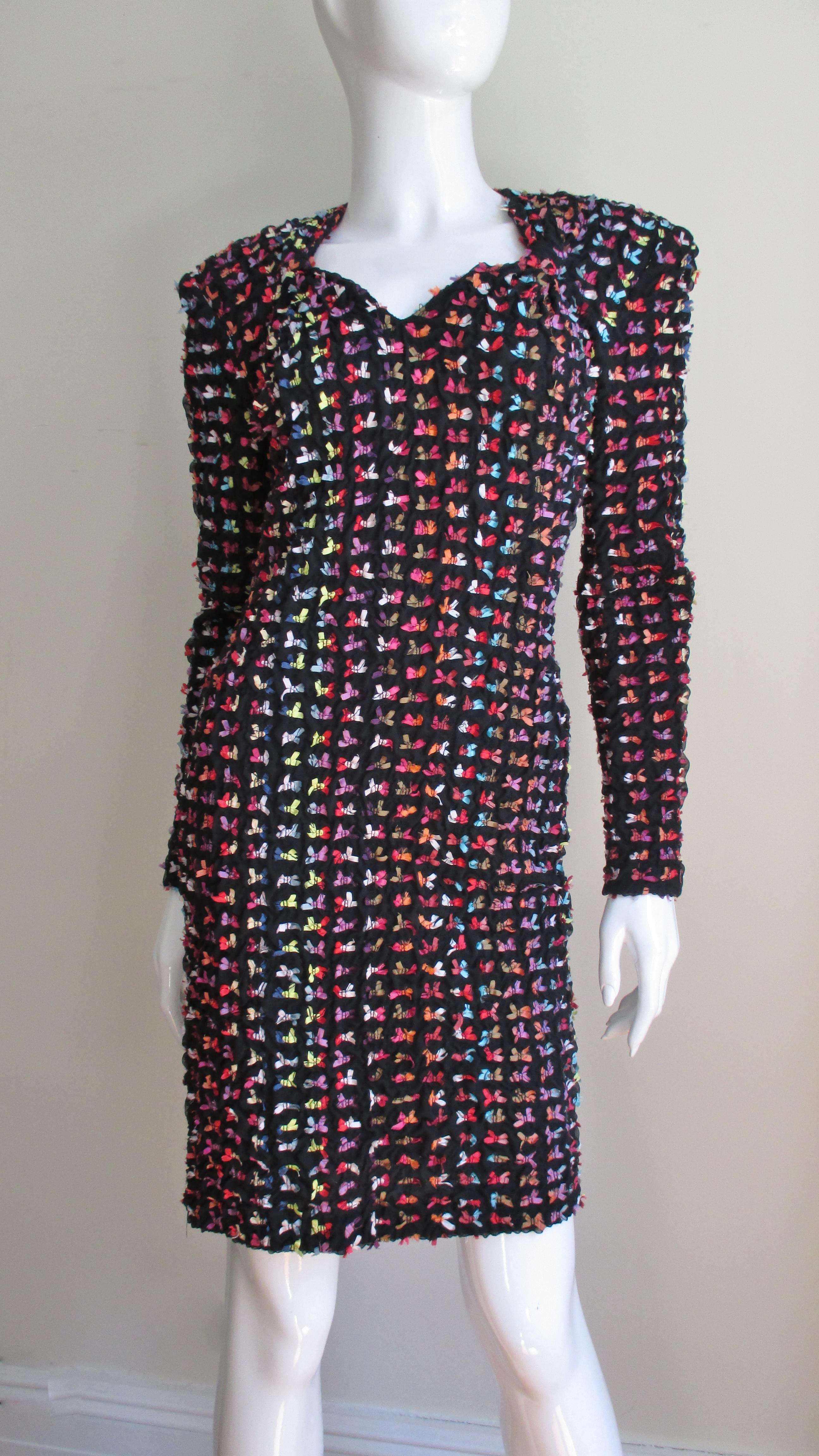 A fabulous black  knit dress from Patrick Kelly covered in tiny rainbow colored silk bows. It is semi fitted with a sweetheart neckline and long sleeves.  It is unlined with shoulder pads and a back zipper.
Fits sizes Small, Medium.

Bust 