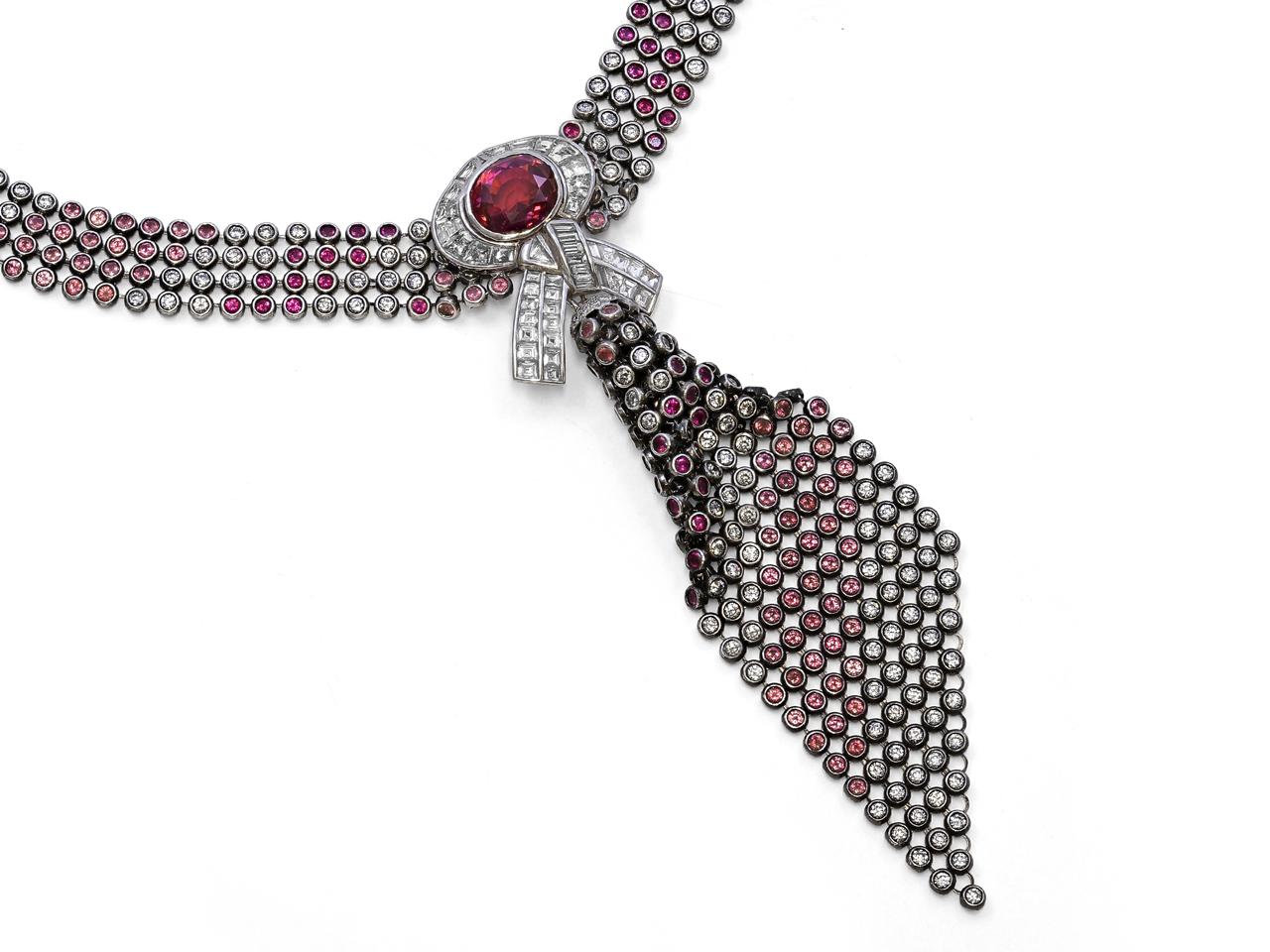 Diseñado por Patrick Mauboussin, este impresionante collar exhibe 12,17 quilates de diamantes, 6,41 quilates de zafiros, 6,30 quilates de zafiros rosas y 3,15 quilates de rubíes. Su pieza central presenta un zafiro púrpura certificado (Informe
