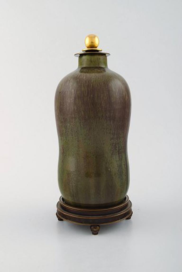 Patrick Nordstrøm / Carl Halier for Royal Copenhagen, lidded stoneware vase with bronze foot and bronze lid by Knud Andersen (Denmark). 1930s-1940s. Beautiful glaze in green and brown shades.
Stamped. 30/42.
Measures: 23.5 cm x 10 cm.
In perfect