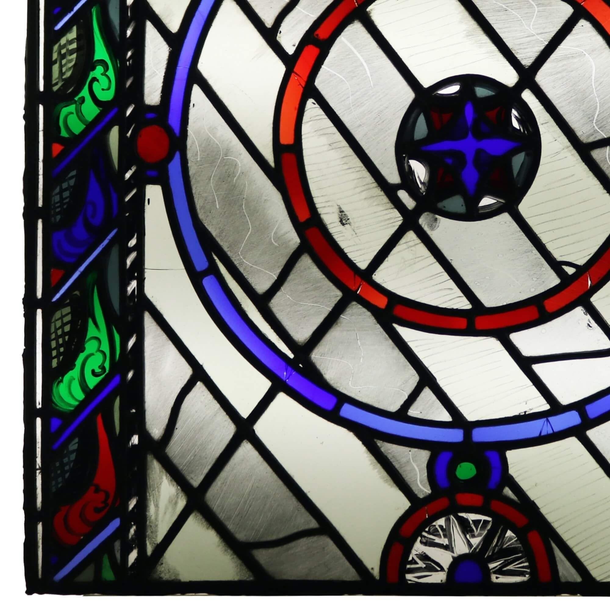 A contemporary leaded glass window from the studio of Patrick Reyntiens (1925-2021). Attributed to the artist, this stained glass panel depicts a vibrant design detailed with circles in red and blue between colourful vertical panels to either side.