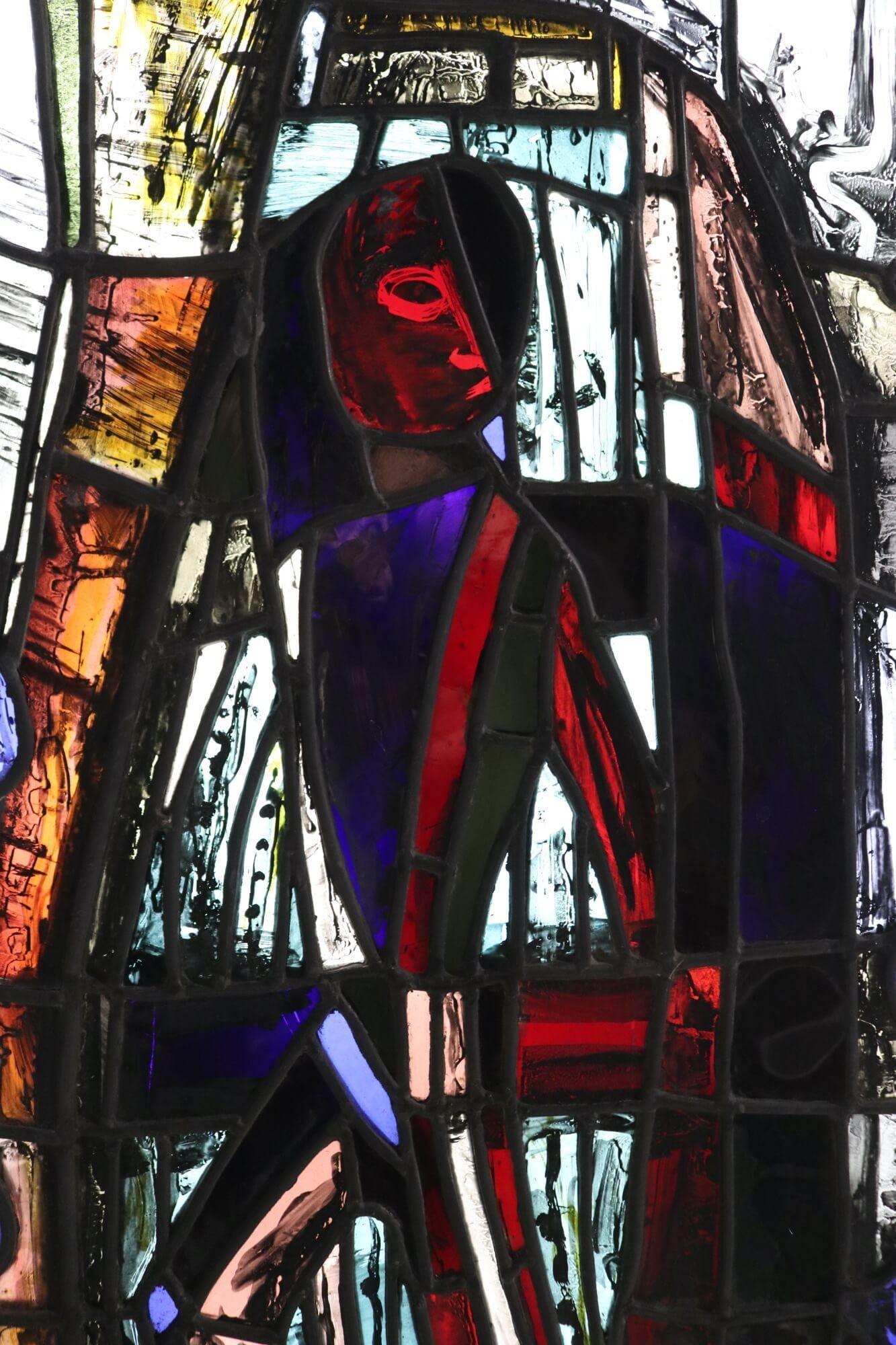 A figurative stained glass window from the studio of Patrick Reyntiens (1925-2021). Attributed to the artist, this stained glass panel depicts an abstract design with hand painted details around what appears to be a central figure. It is one of