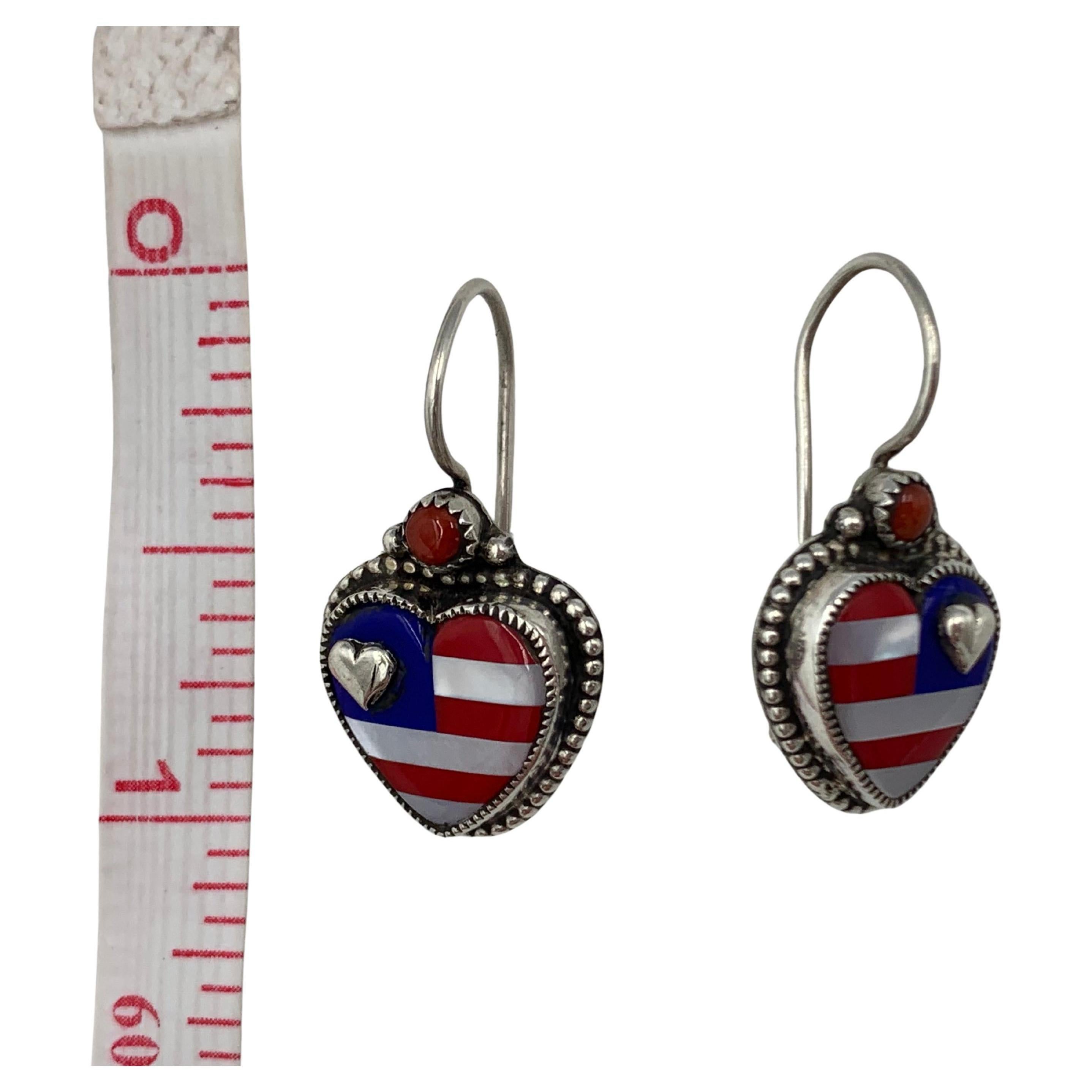 Las incrustaciones de nácar, lapislázuli azul y coral rojo crean un motivo de bandera. Los corazones de plata de ley realzan el aire patriótico de estos pendientes.

El conjunto de cabujones de corazón mide 3/8″ x 3/8″ con alambres franceses.