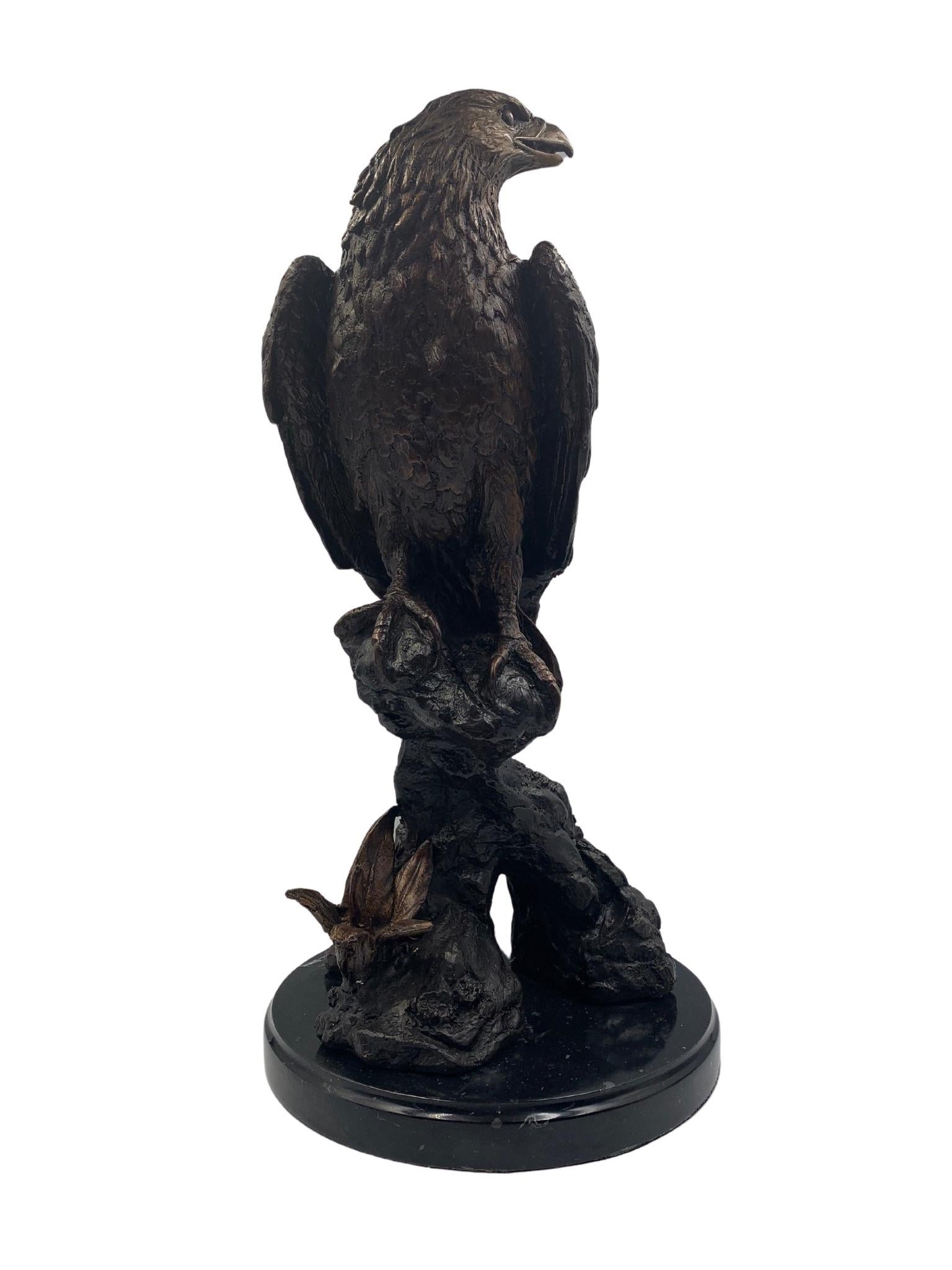 Il s'agit d'une sculpture en bronze du 20e siècle, d'après Jules Moigniez, représentant un aigle sur un perchoir rocheux. Le digne aigle a les ailes repliées et la tête tournée sur le côté, ce qui témoigne d'un travail artisanal exquis. Des plumes