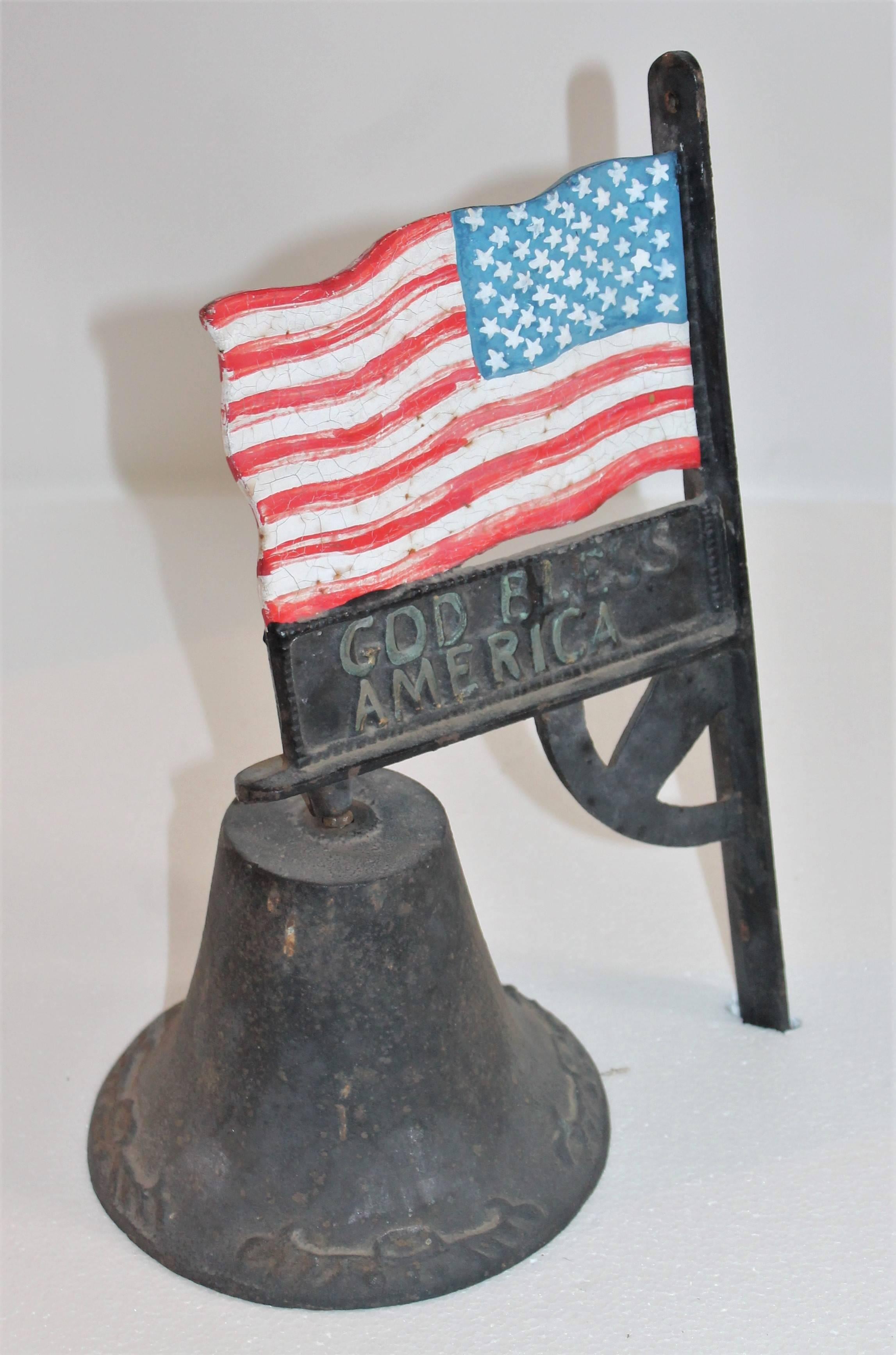 This interesting all original black painted wall-mounted bell and American flag is in good condition and in working order. The flag is faded on one side due to the bad weather or sun fade. Was hung outside of the home. Probably front porch or entry